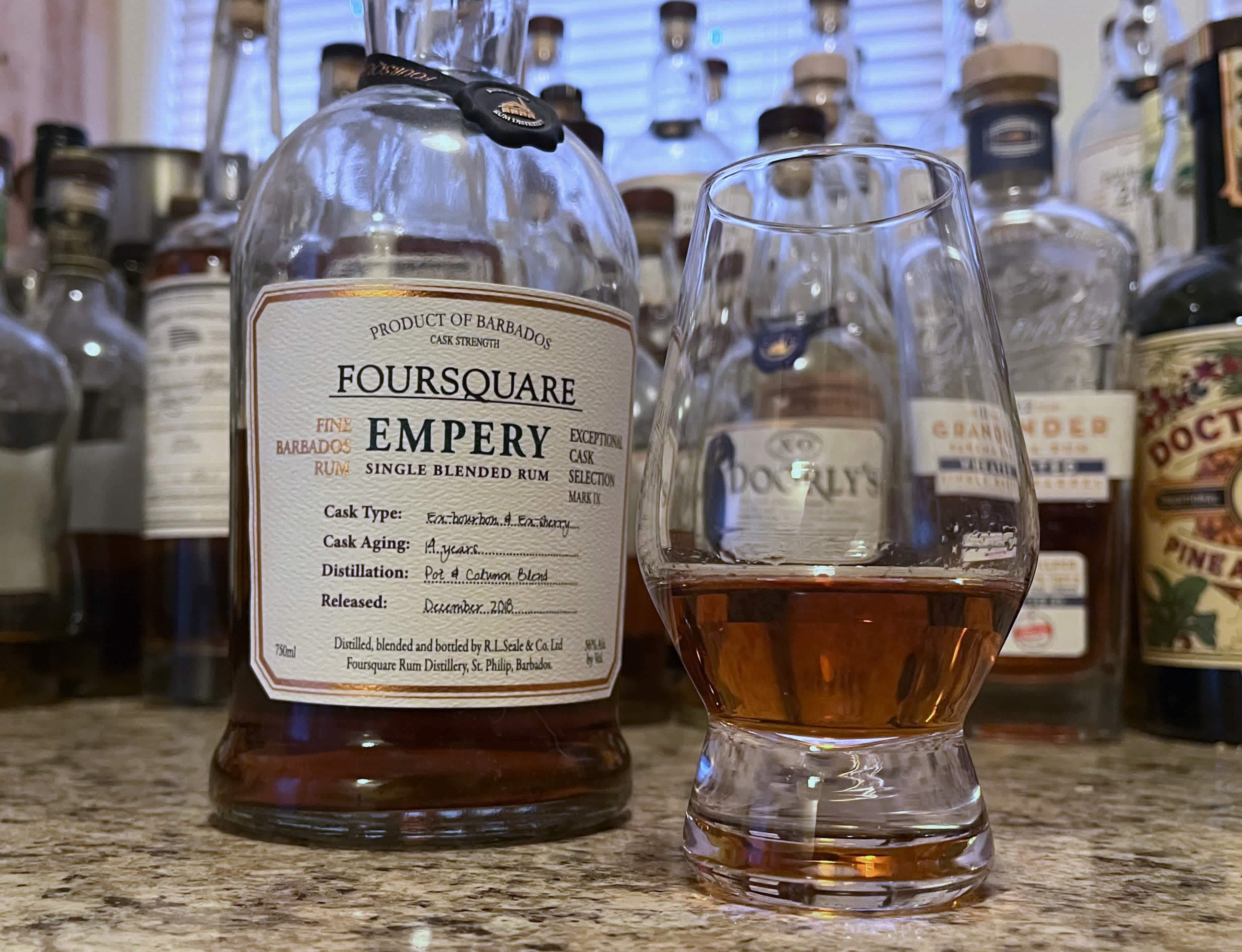 A bottle of Foursquare Empery next to a glencairn of rum on a kitchen counter