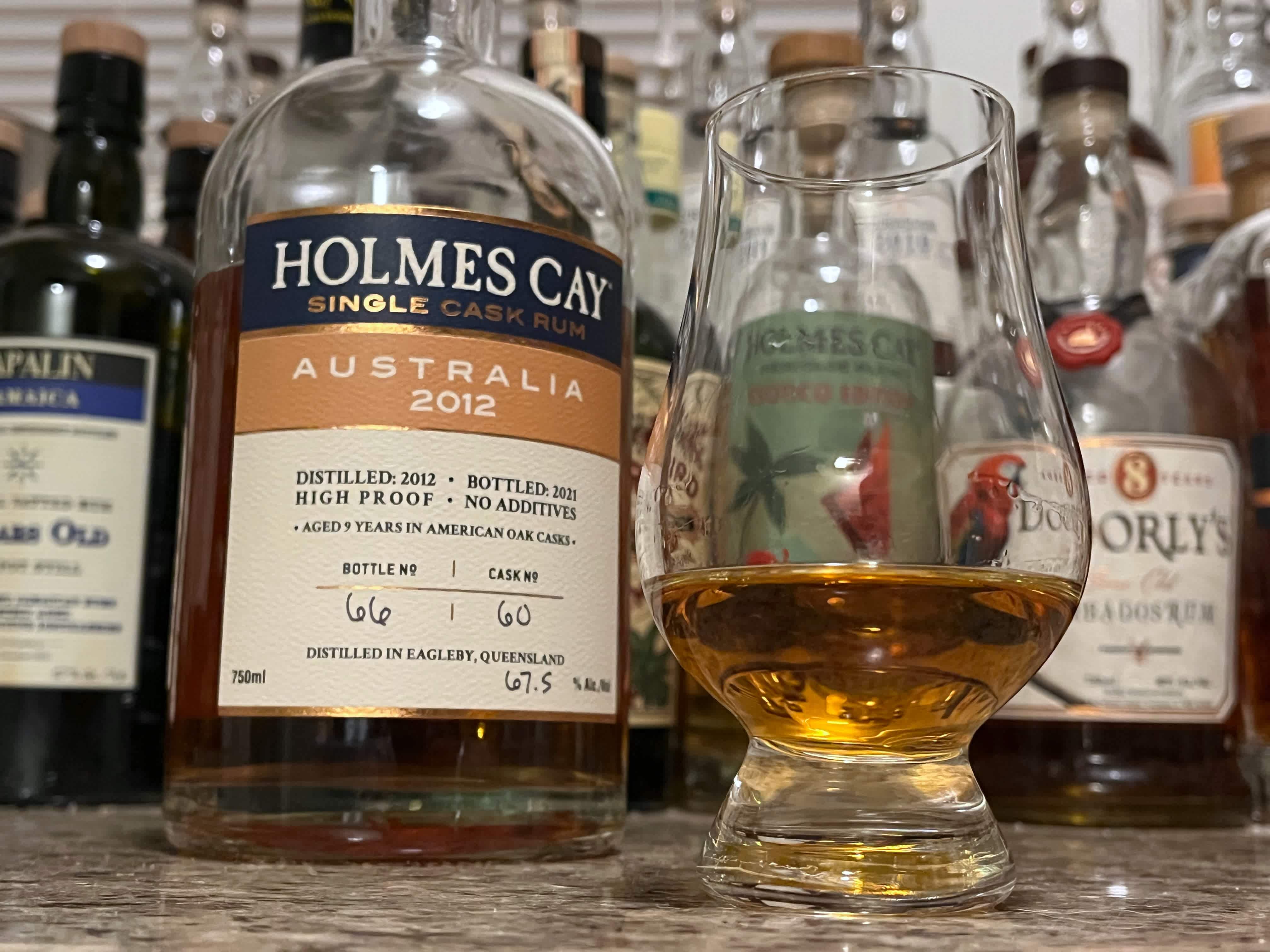 Bottle of Holmes Cay Australia 2012 sitting next to a rum-filled glencairn