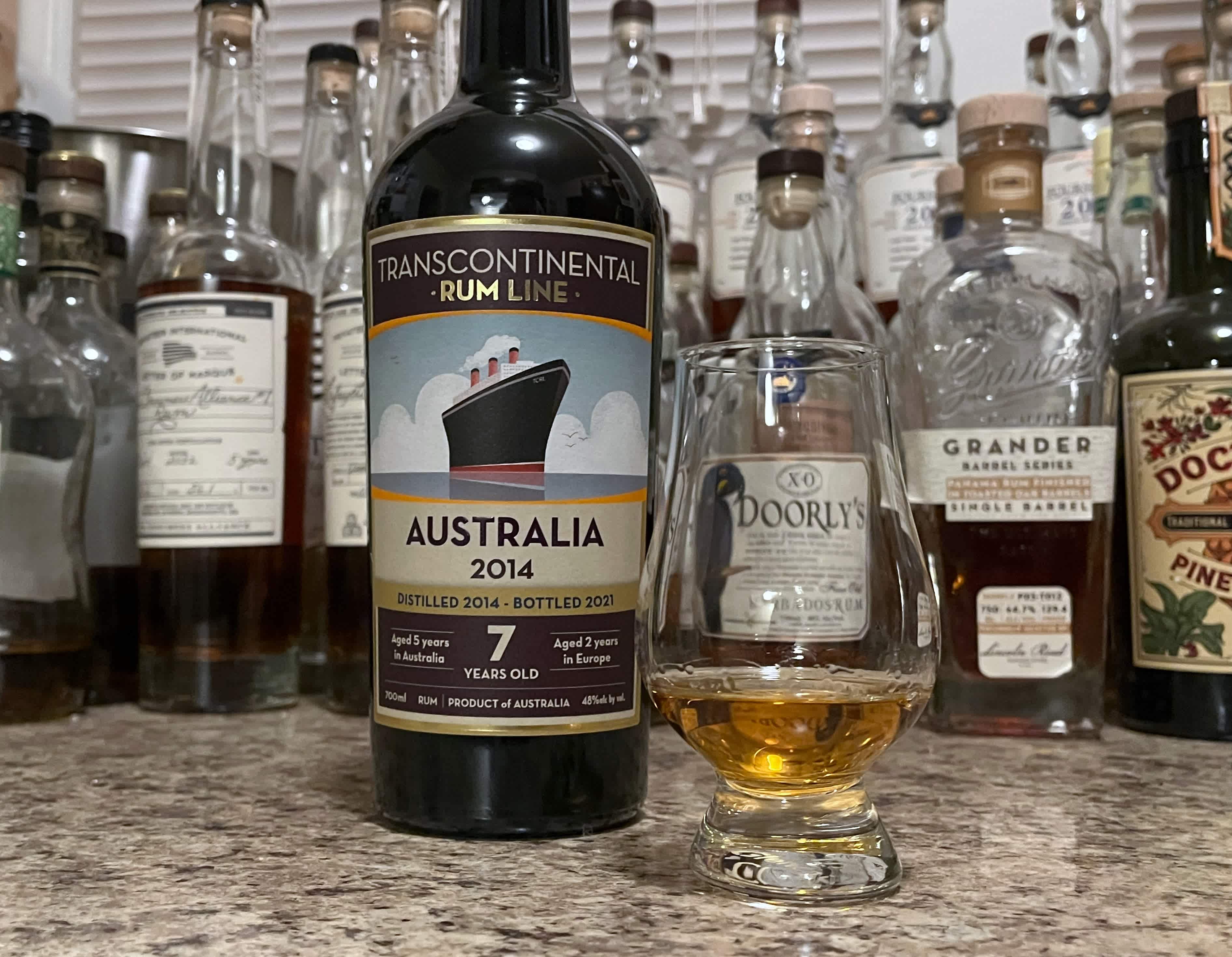 Bottle of TCRL Australia 2014 sitting next to a rum-filled glencairn