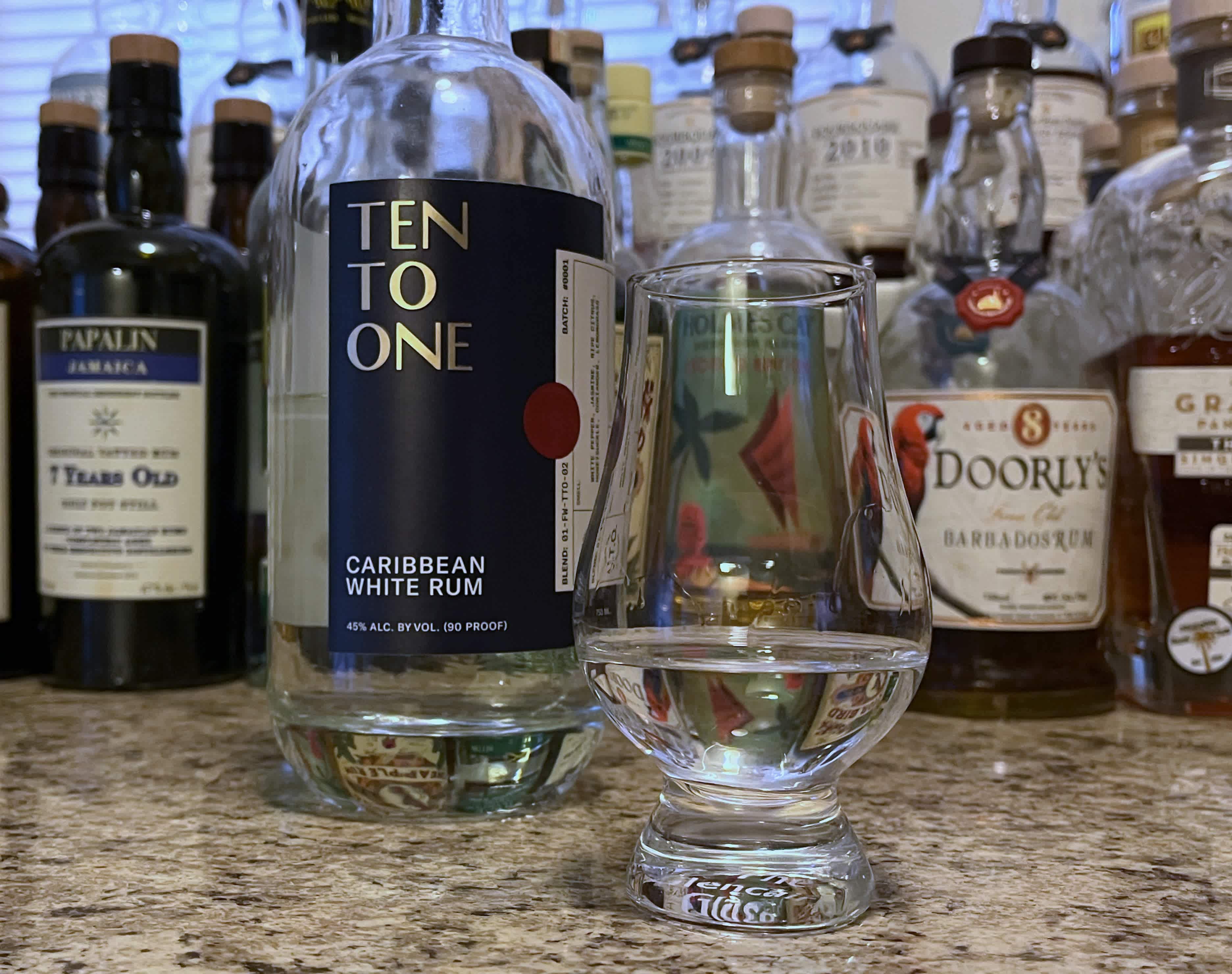 A bottle of Ten to One White next to a glencairn of rum