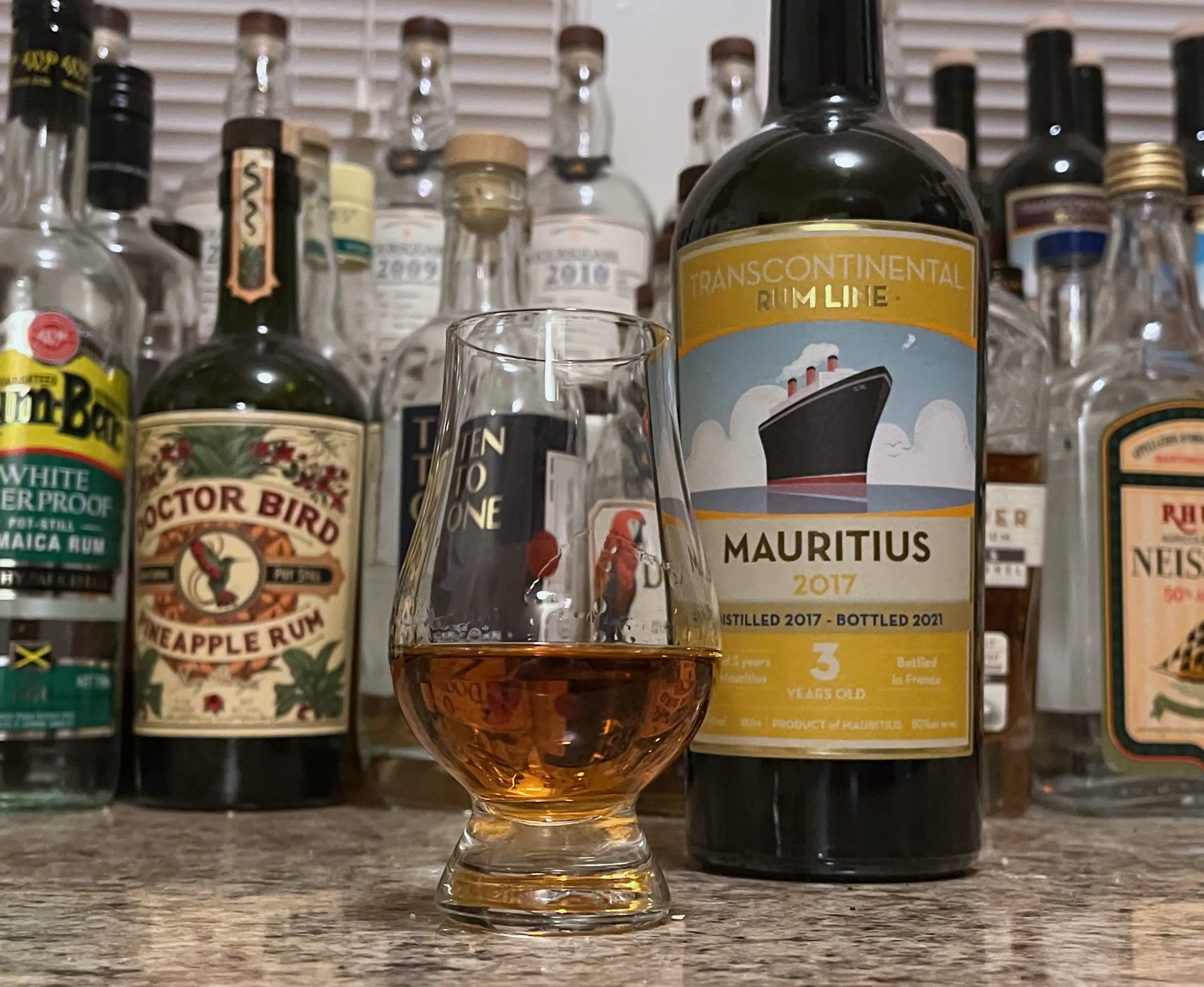 Bottle of TCRL Mauritius 2017 sitting next to a rum-filled glencairn