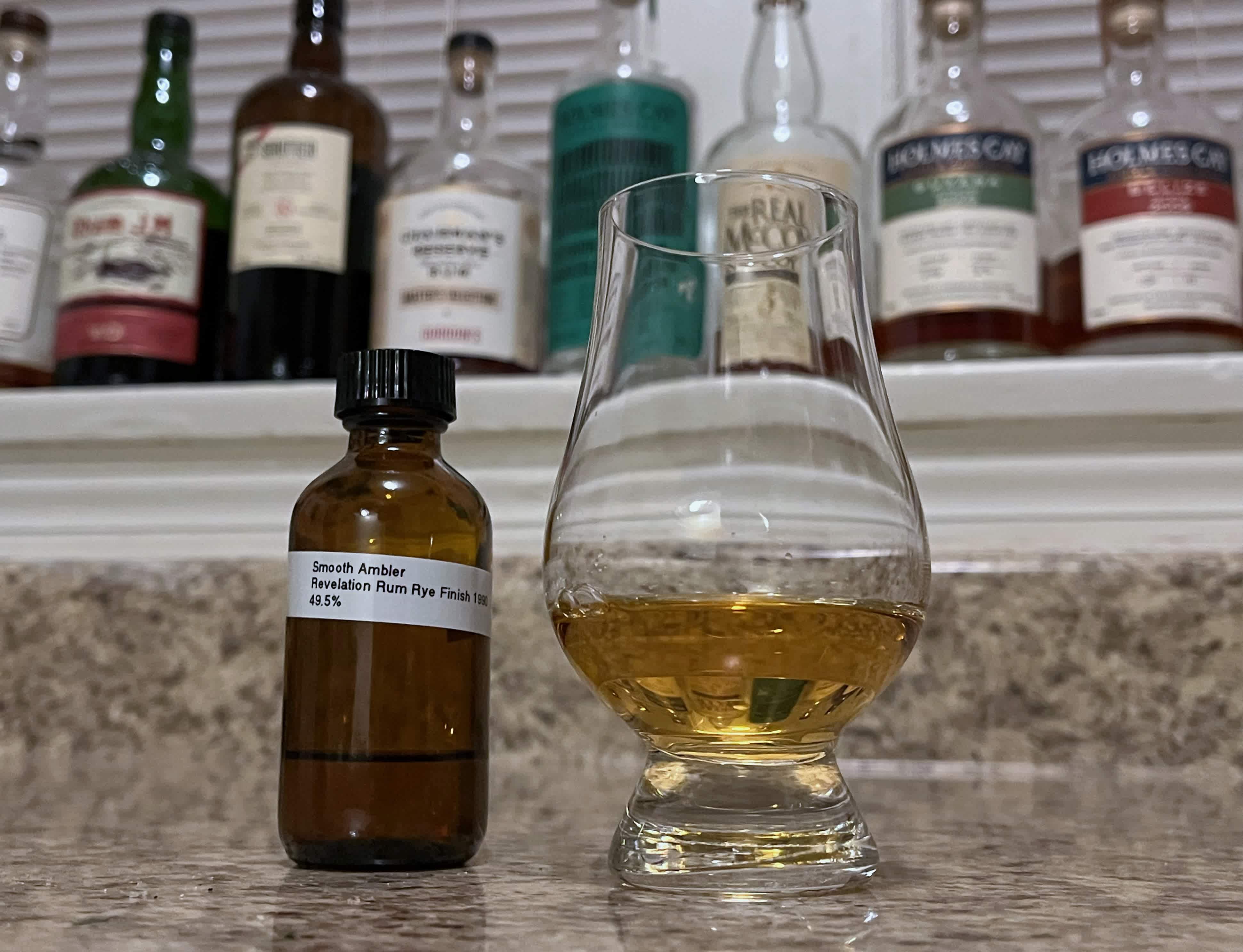 Smooth Ambler sample bottle next to a glass of rum