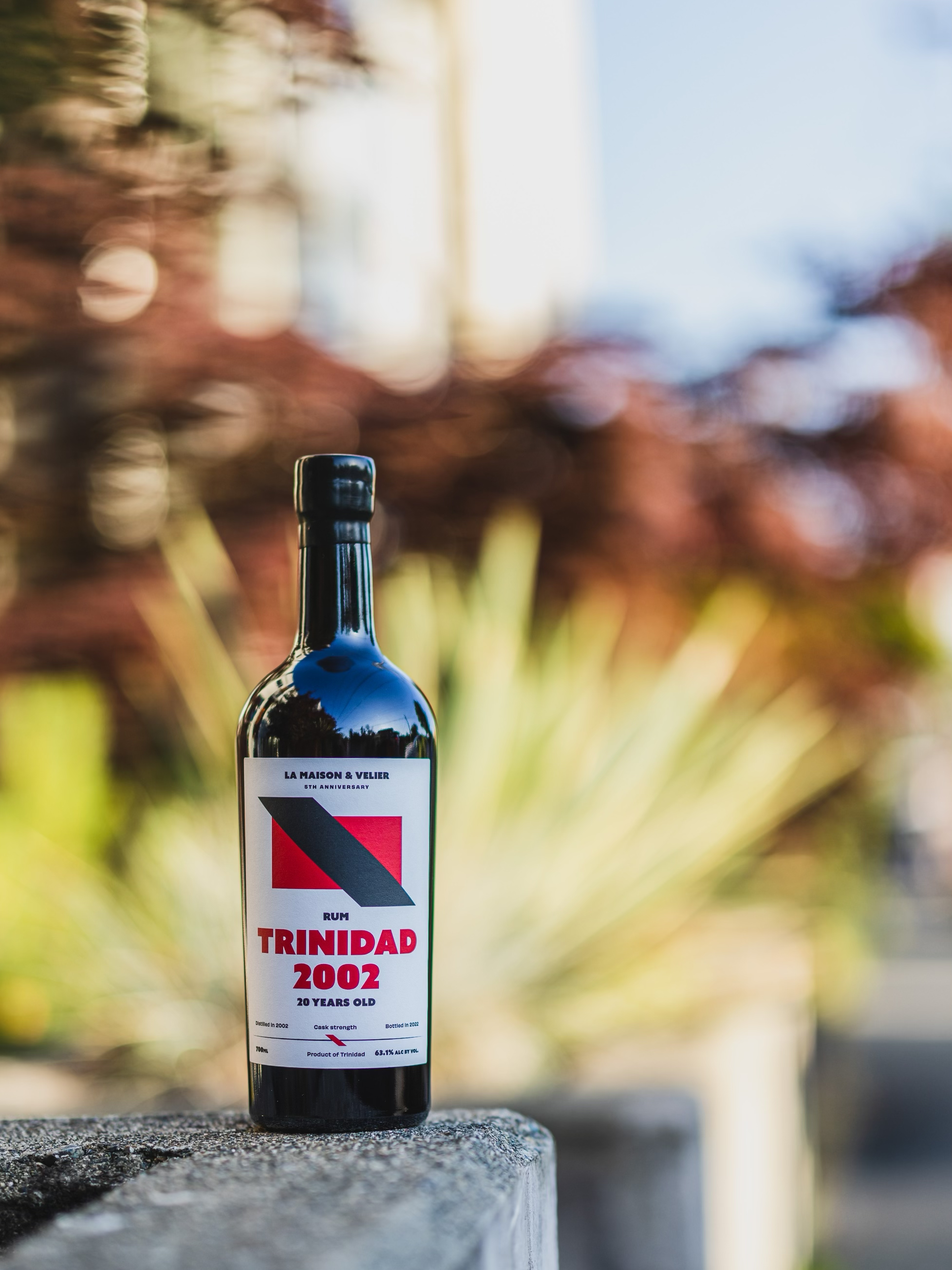 Flag Series Trinidad 1998 bottle sitting on a table with a bokeh background, credit: La Maison & Velier