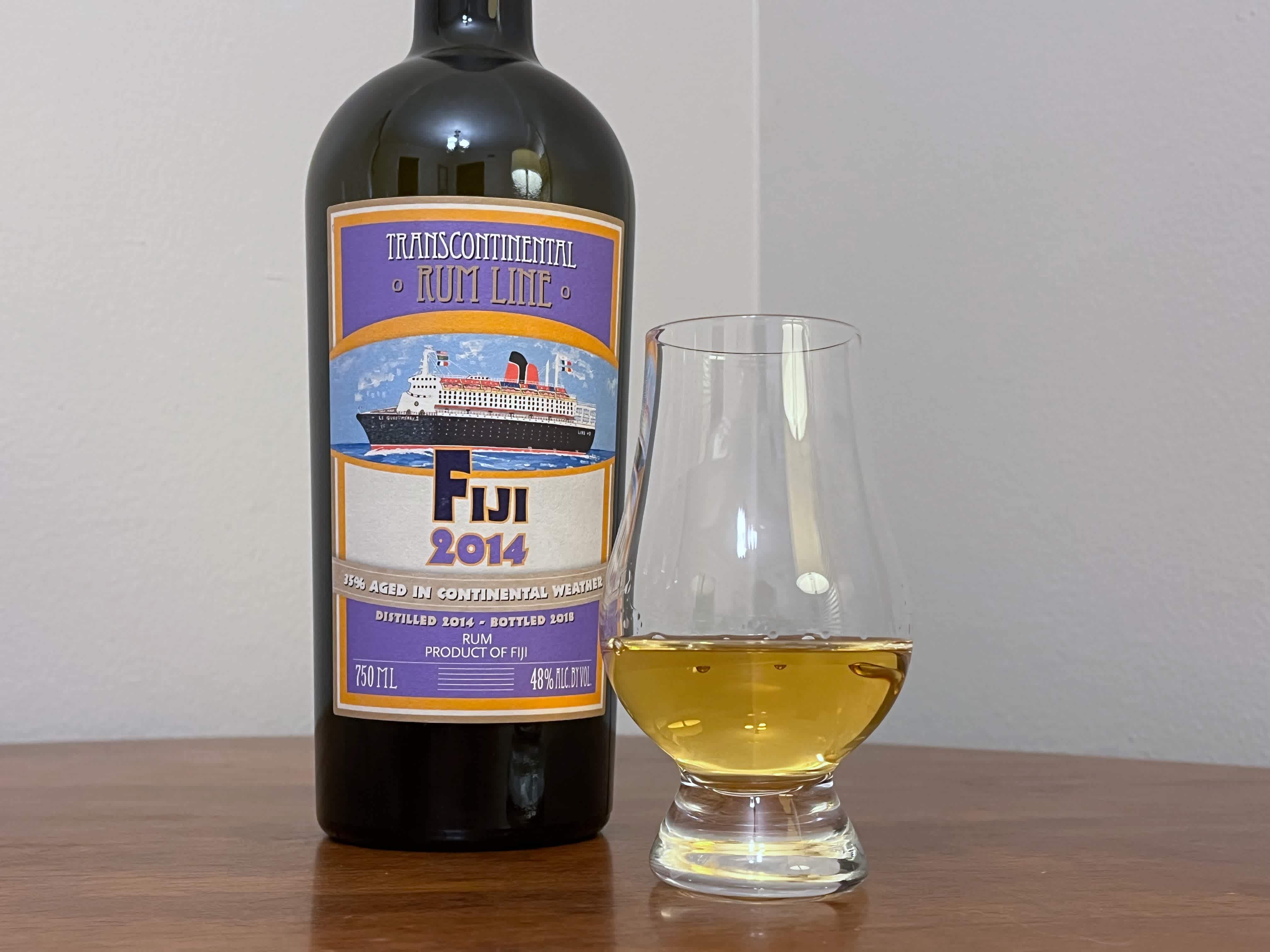 A bottle of TCRL Fiji 2014 next to a glencairn of rum