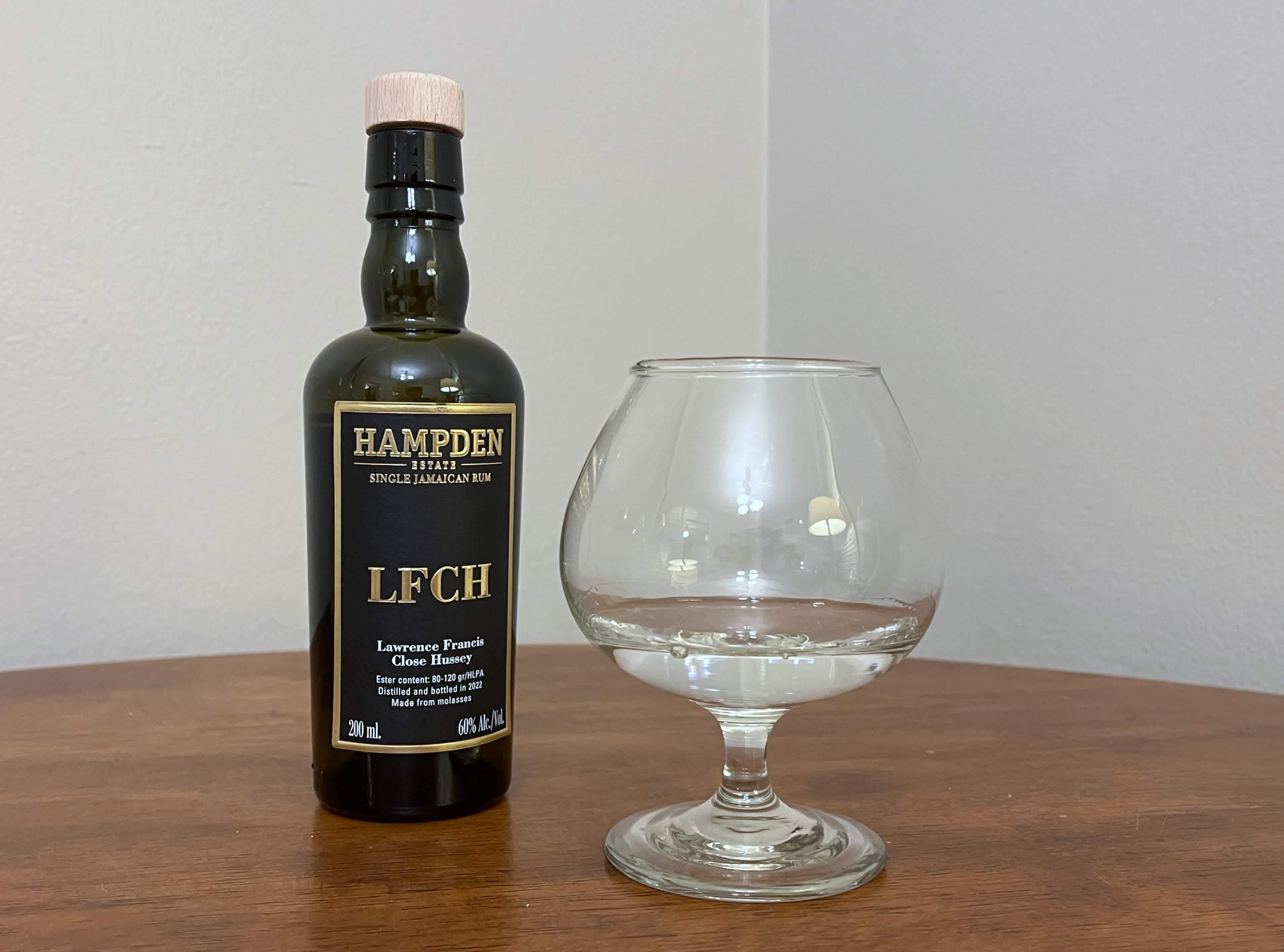 A bottle of Hampden 8 Marks LFCH next to a glass of rum