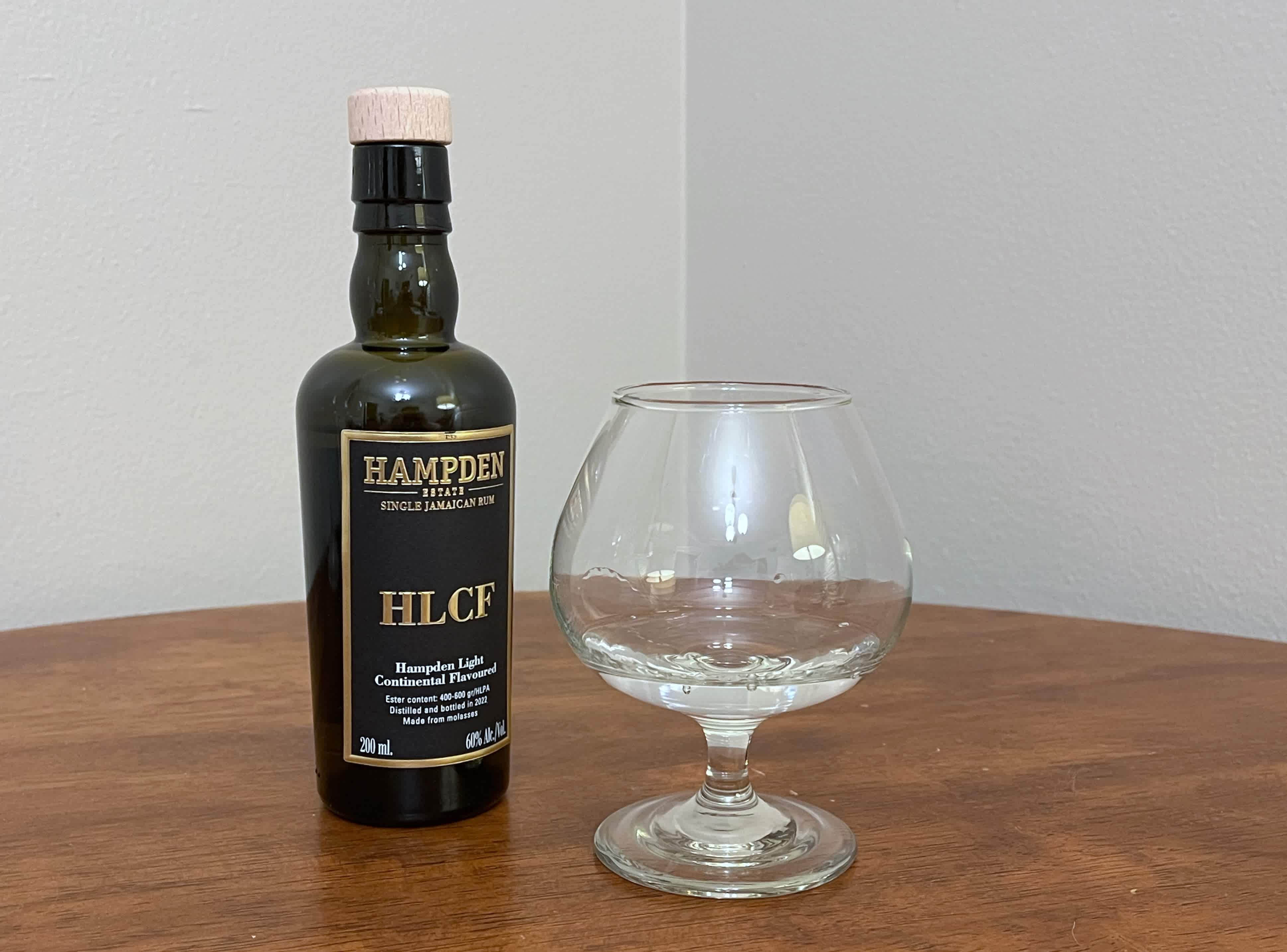 A bottle of Hampden 8 Marks HLCF next to a glass of rum