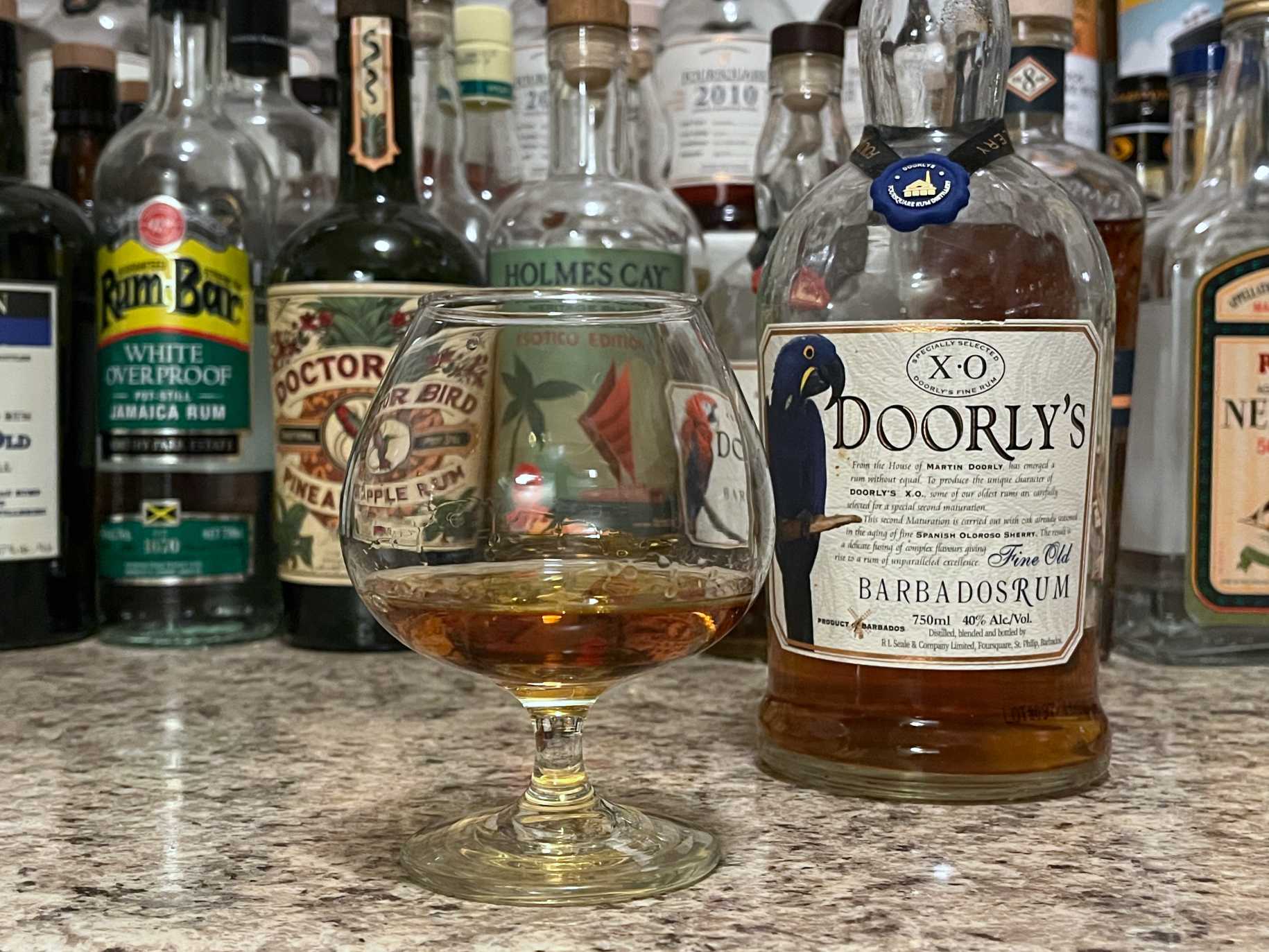 A bottle of Doorly's XO next to a glencairn of rum