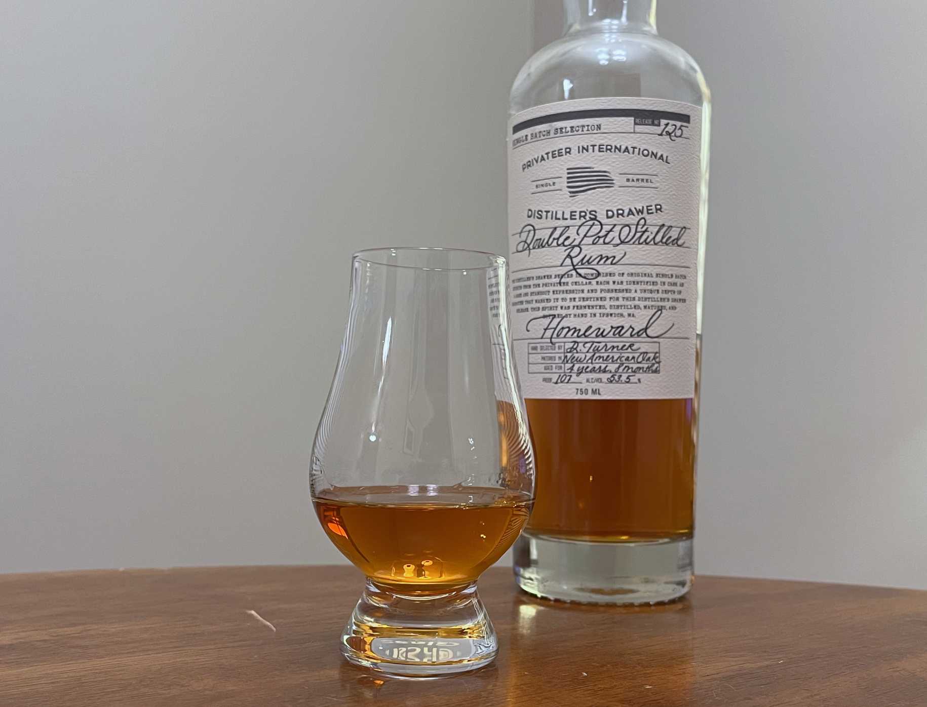 A bottle of Privateer DD Homeward next to a glencairn of rum on a kitchen counter