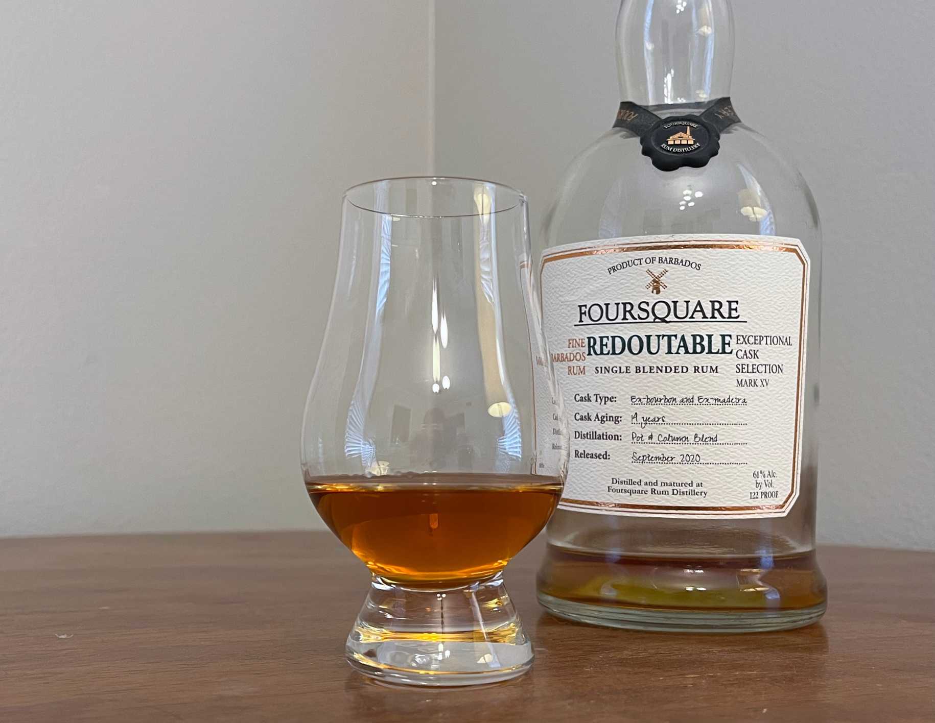 A bottle of Foursquare Redoutable next to a glass of rum
