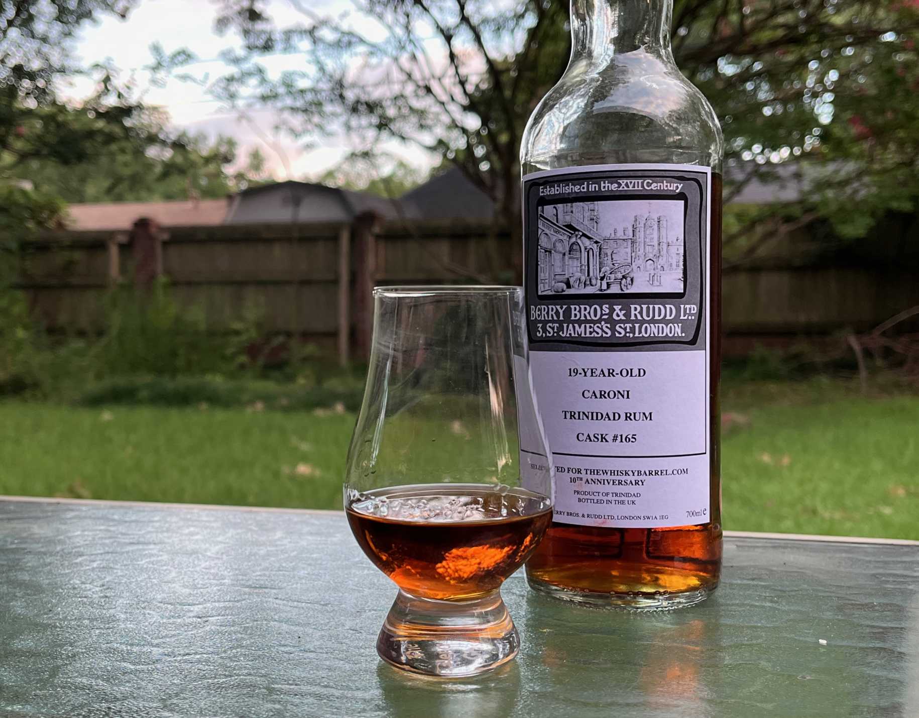 A bottle of Berry Bros. & Rudd Caroni next to a glass of rum