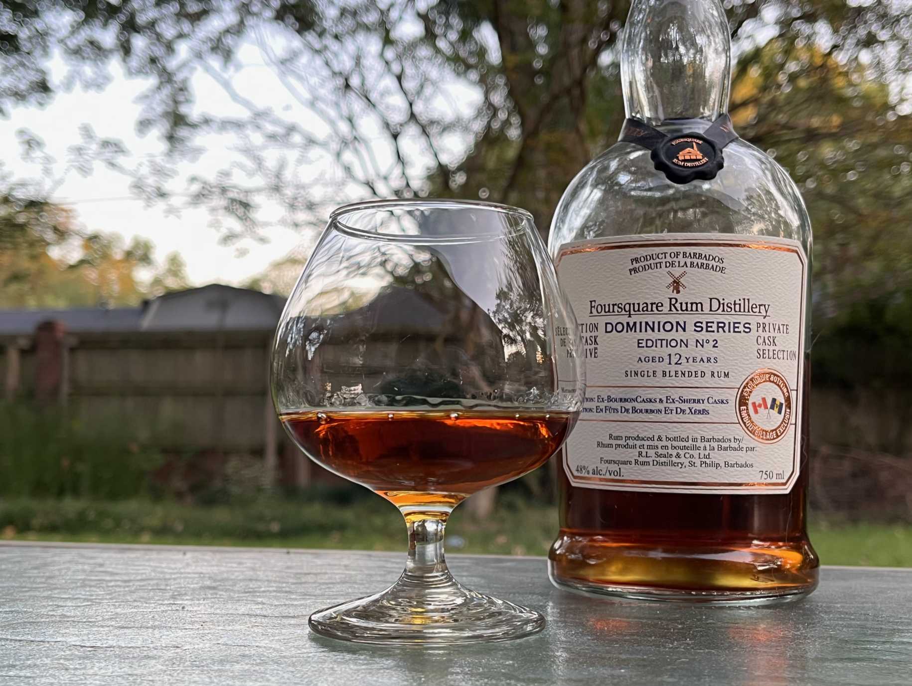 A bottle of Foursquare Dominion Series Edition No. 2 next to a glass of rum