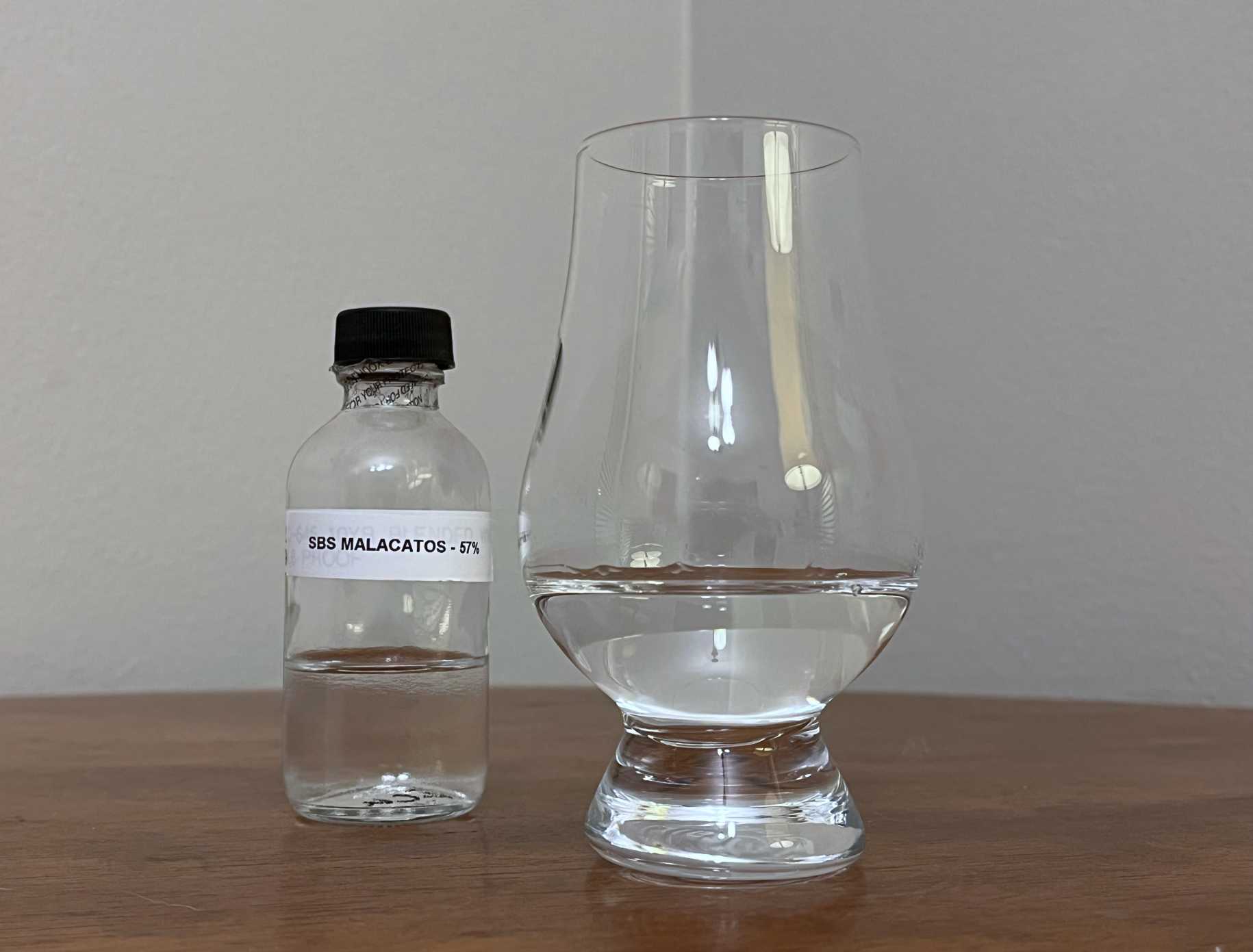 A bottle of S.B.S. Origins Ecuador Malacatos next to a glass of rum