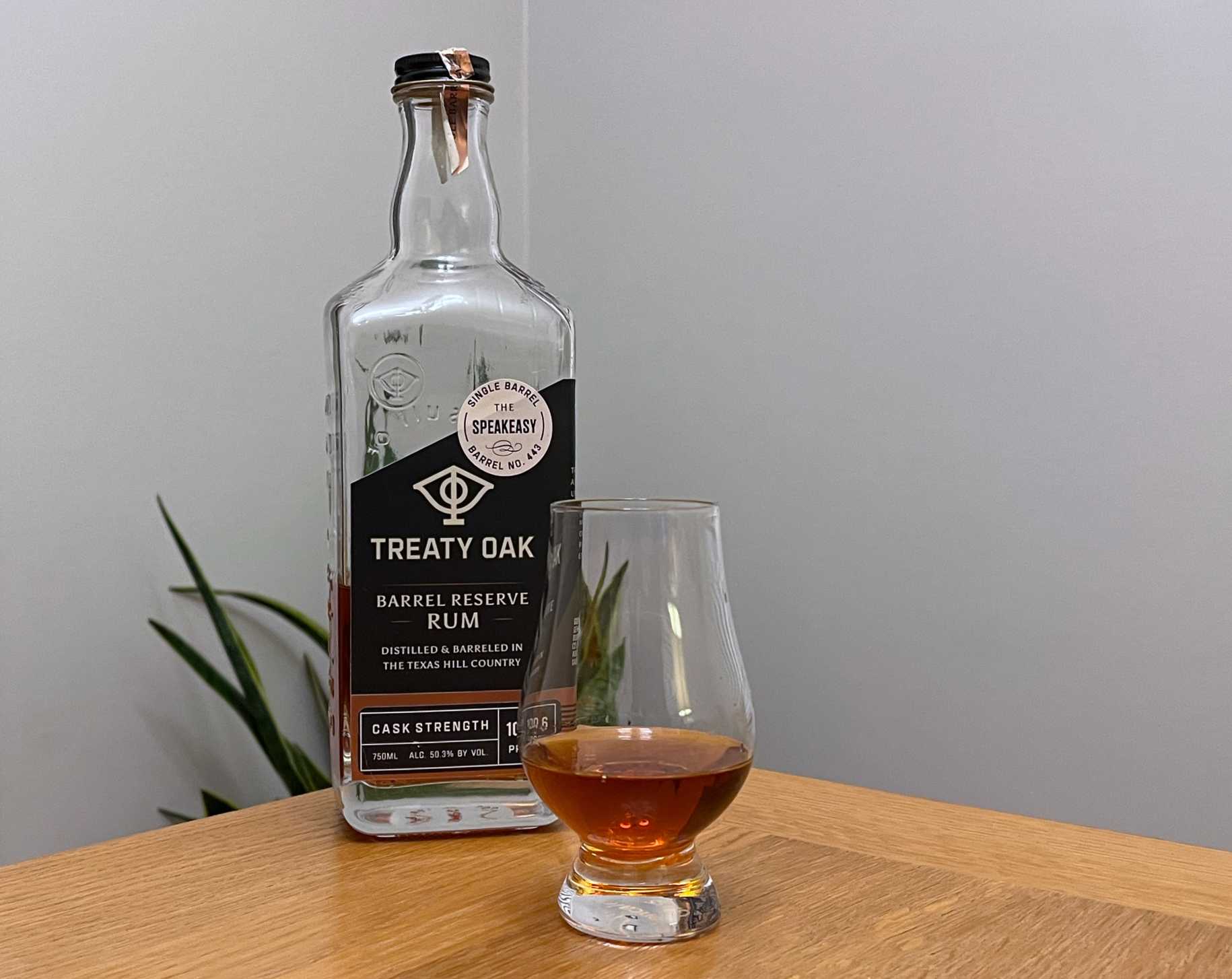 A bottle of Treaty Oak Barrel Reserve Rum - Barrel No. 443 next to a glass of rum