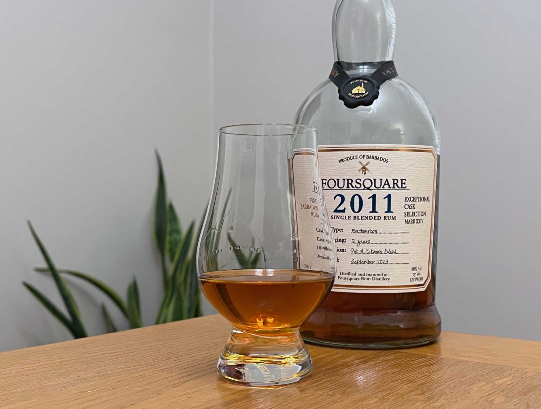 A bottle of Foursquare 2011 next to a glass of rum