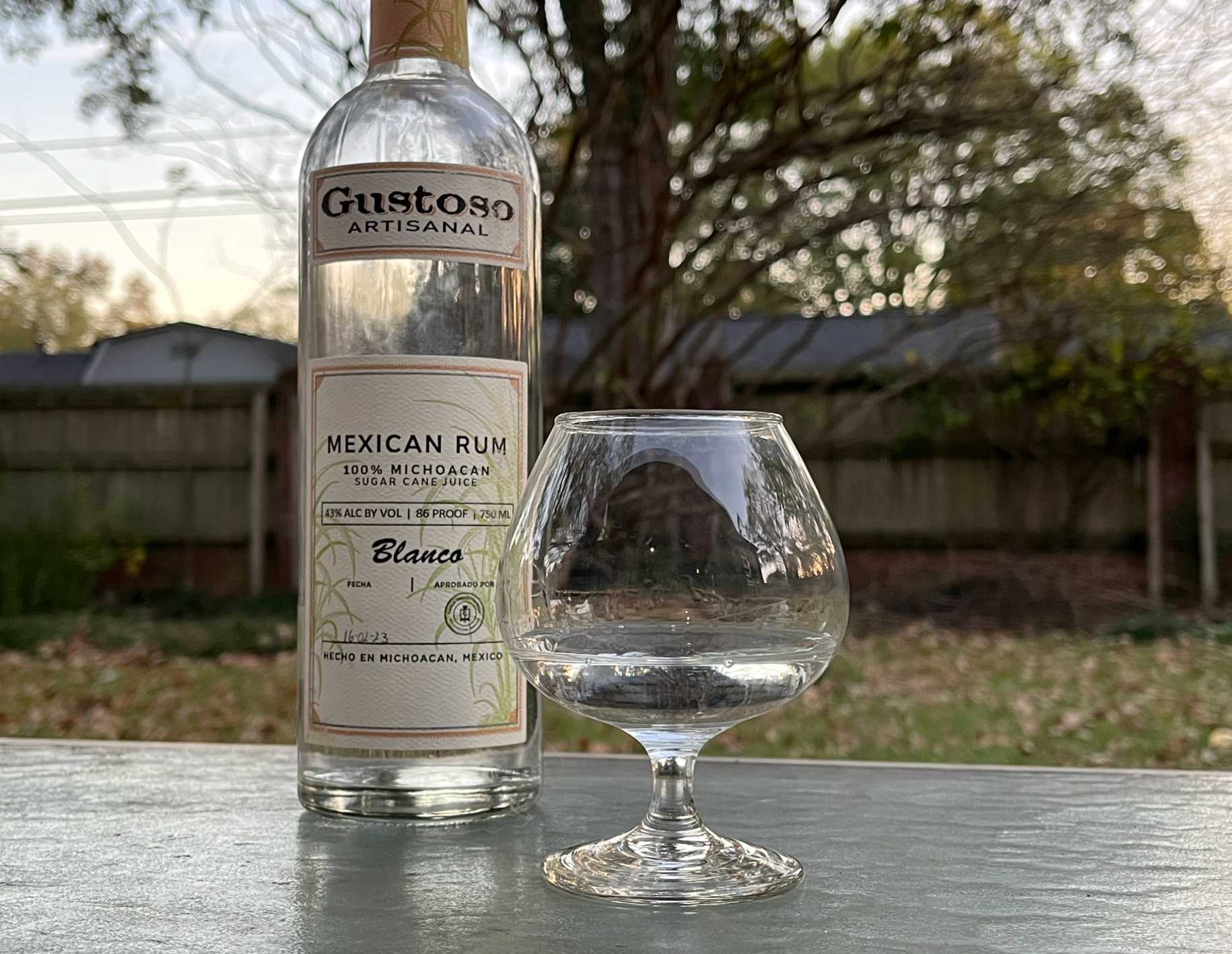 A bottle of Gustoso Blanco next to a glass of rum