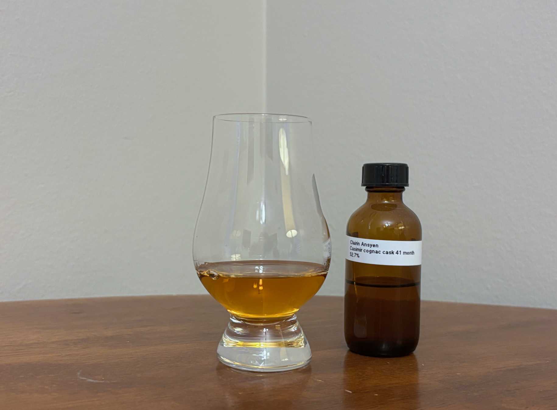 A bottle of Clairin Ansyen Casimir Cognac Cask next to a glass of rum