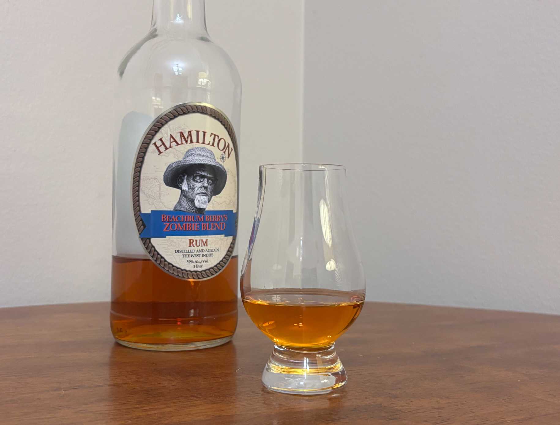 A bottle of Hamilton Beachbum Berry's Zombie Blend next to a glass of rum
