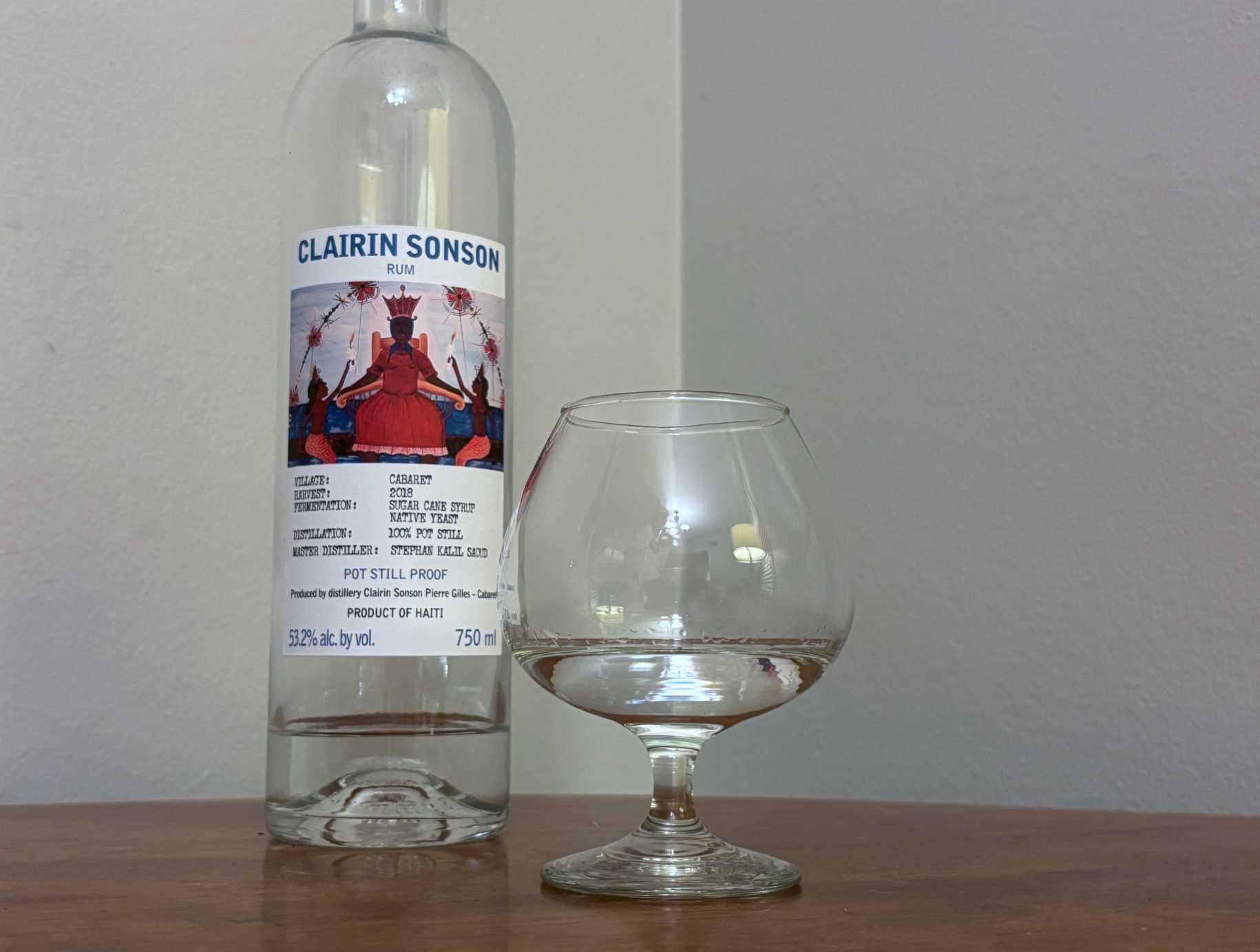 A bottle of Clairin Sonson next to a glass of rum