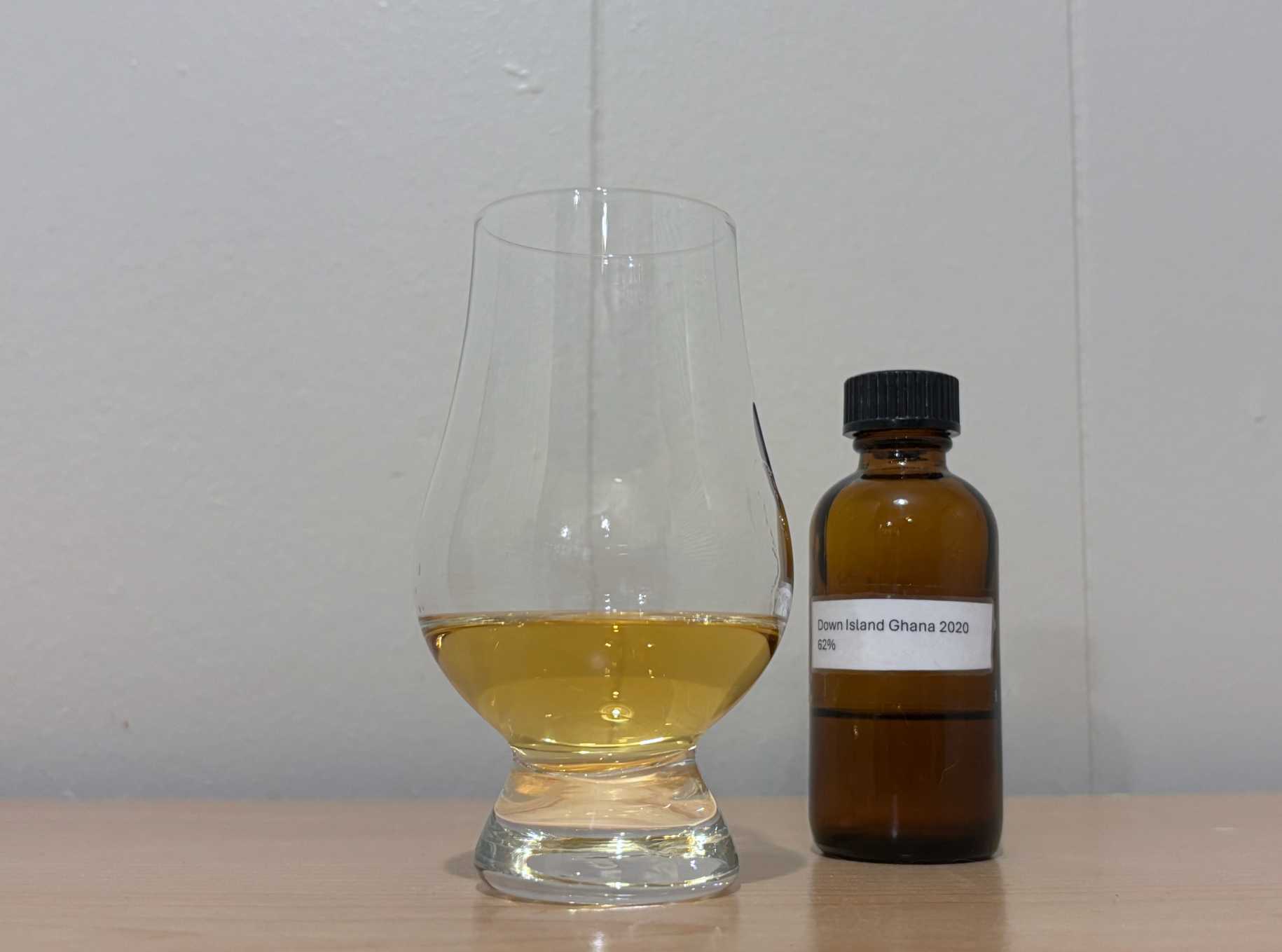 A bottle of Down Island Spirits Ghana 2020 3 year next to a glass of rum