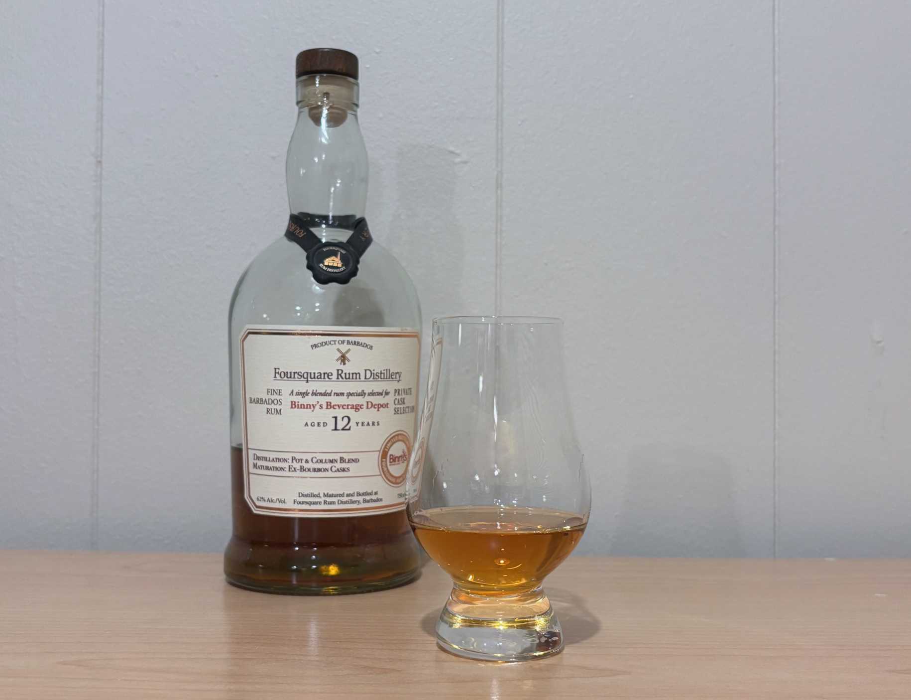A bottle of Foursquare Binny's Private Cask 12 year next to a glass of rum