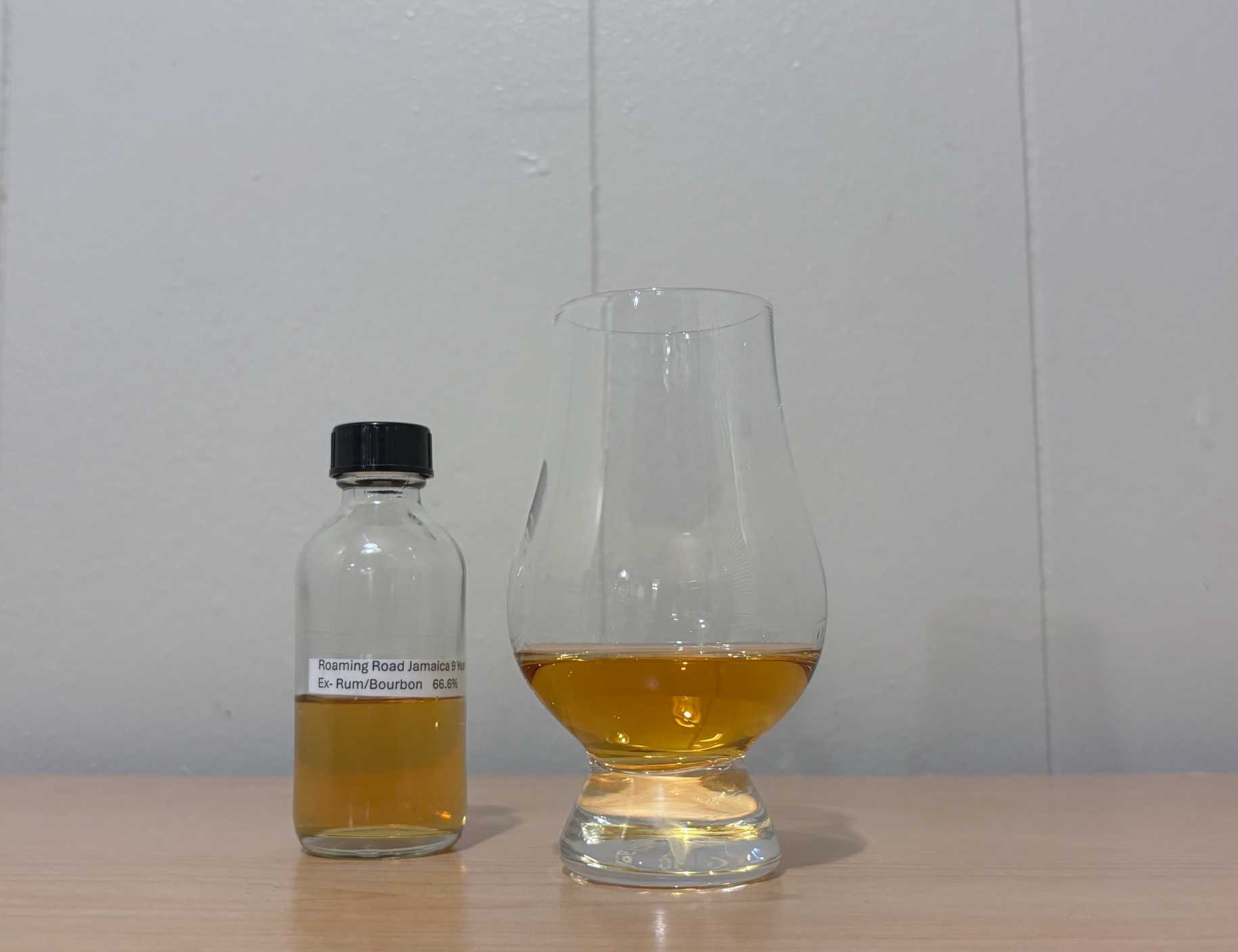 A bottle of Roaming Road Jamaica 9 year next to a glass of rum