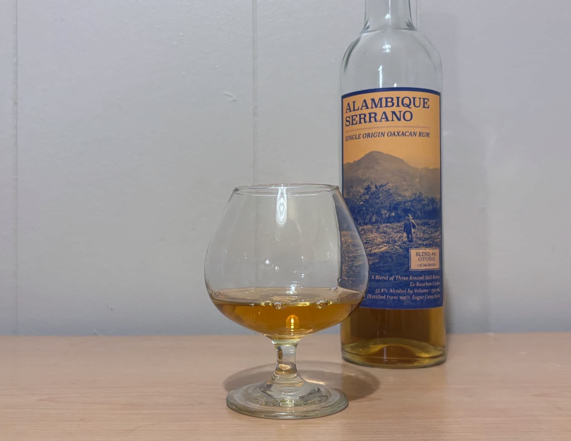 A bottle of Alambique Serrano Blend #6 Otoño next to a glass of rum