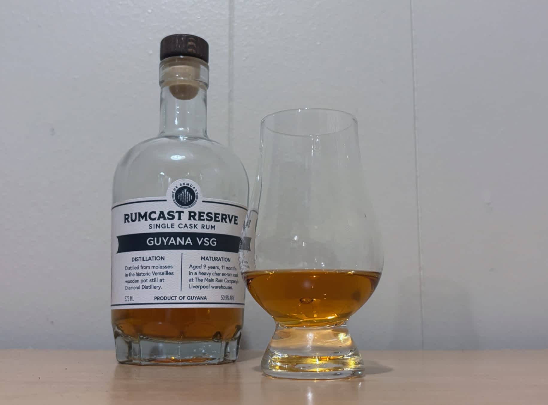 A bottle of Rumcast Reserve Guyana VSG 9yr next to a glass of rum