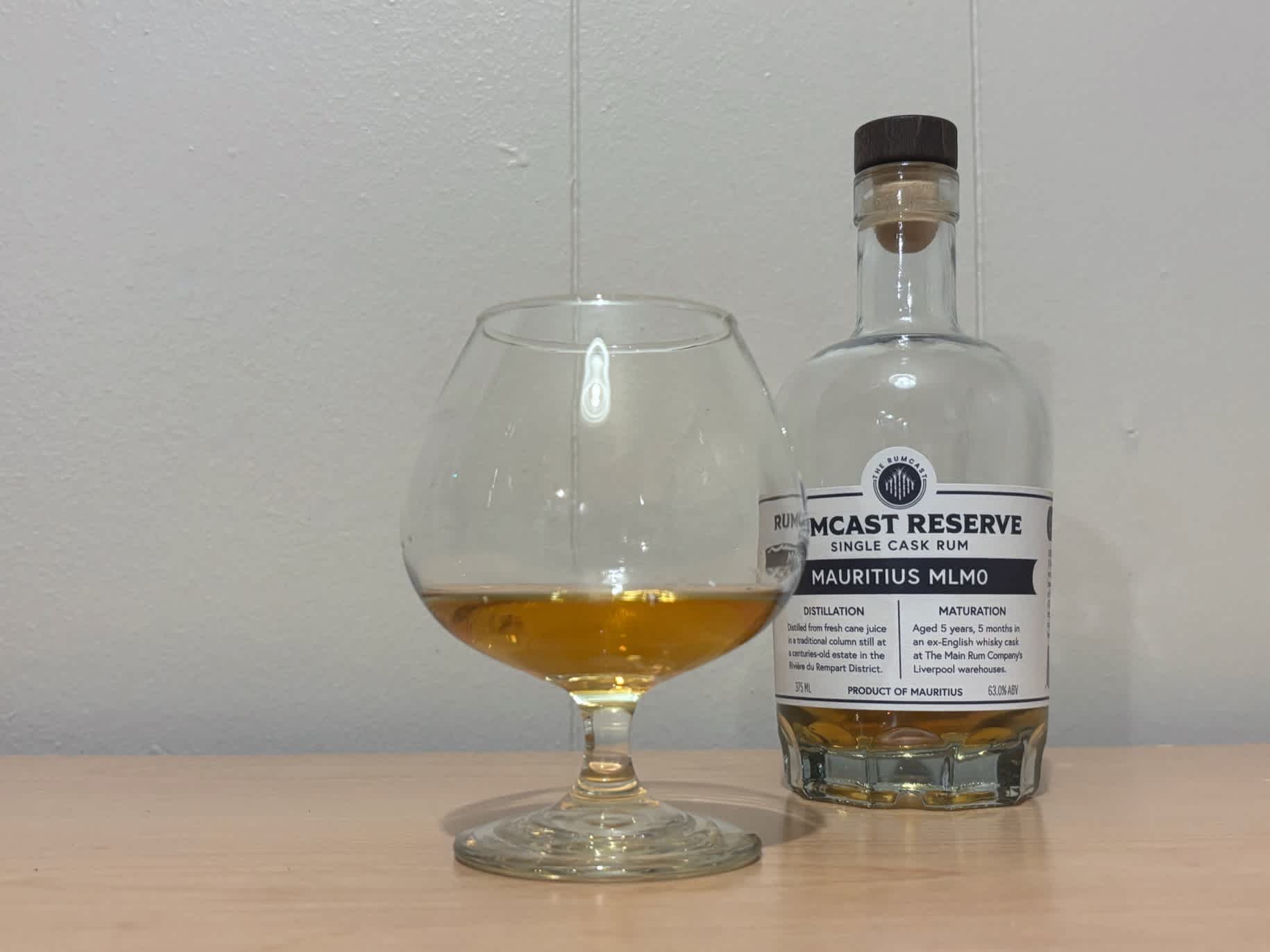 A bottle of Rumcast Reserve Mauritius MLM0 5yr next to a glass of rum