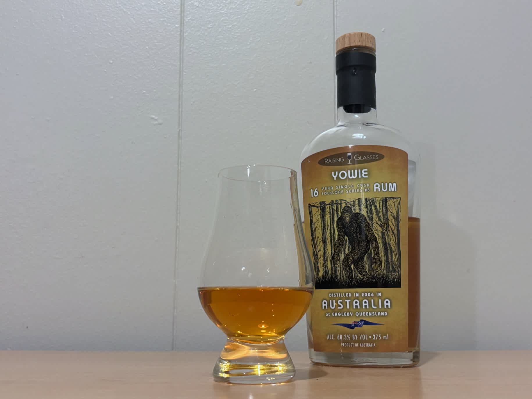A bottle of Raising Glasses Yowie 16yr next to a glass of rum