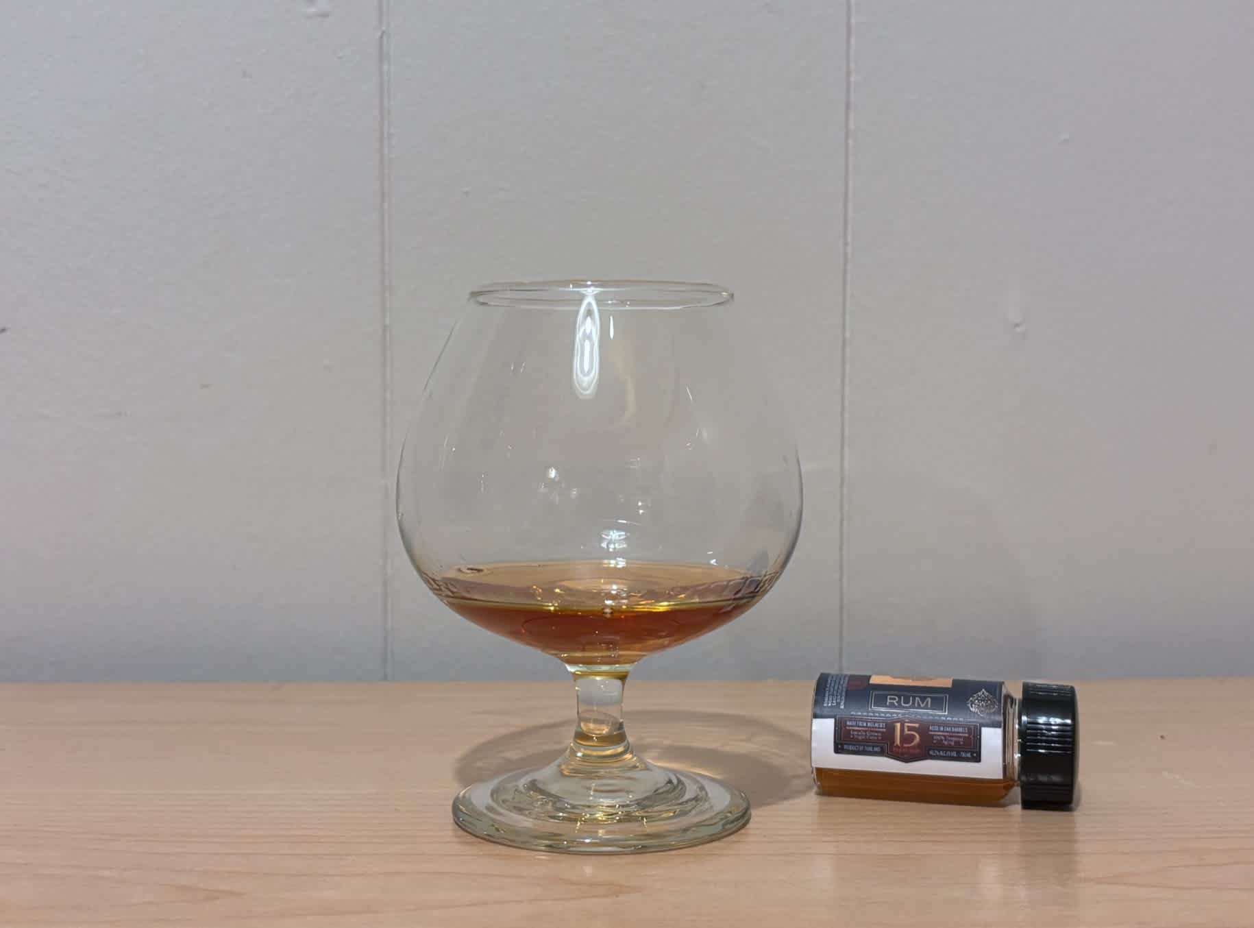 A bottle of Shakara 15yr next to a glass of rum