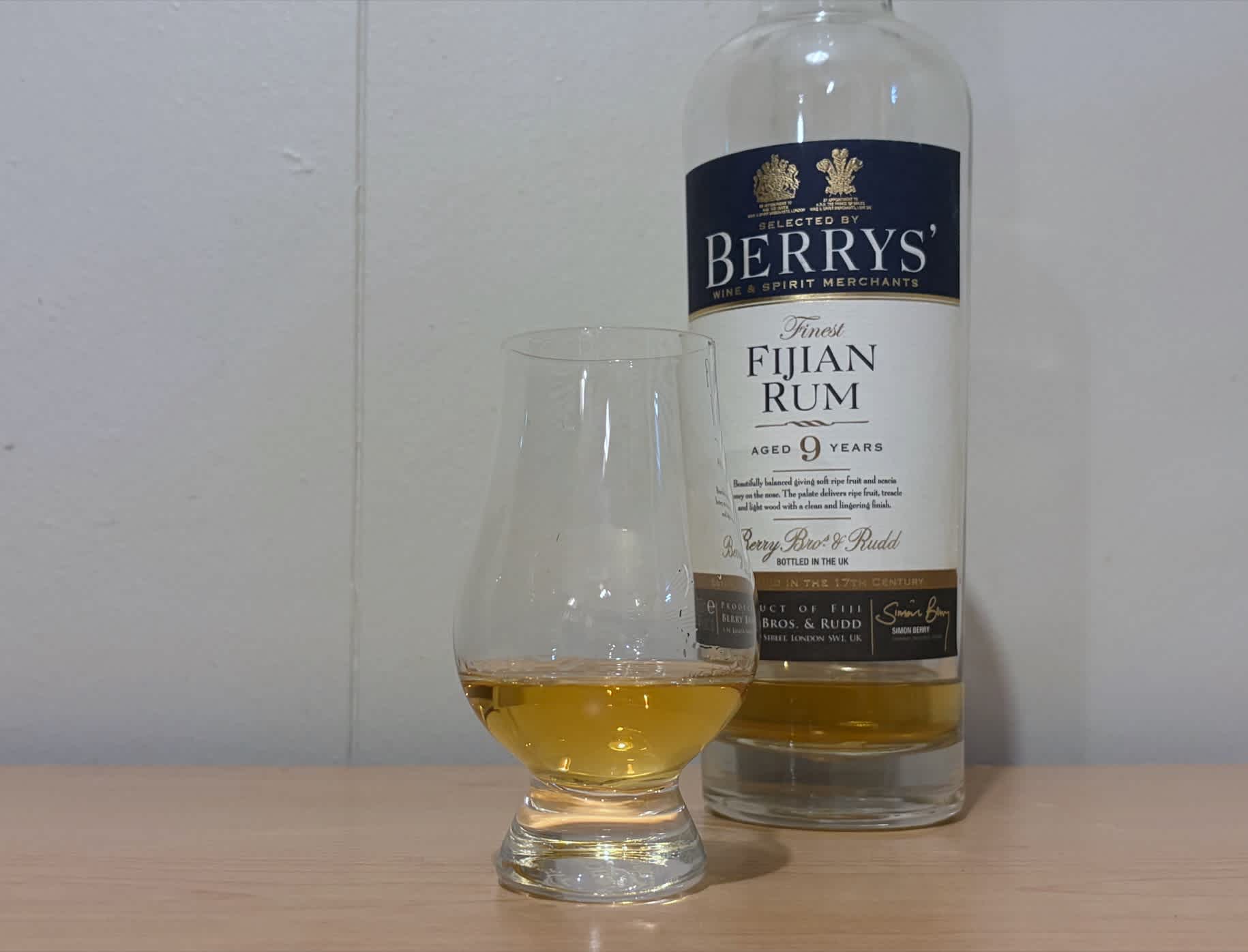 A bottle of Berrys' Finest Fijian Rum 9 year next to a glass of rum