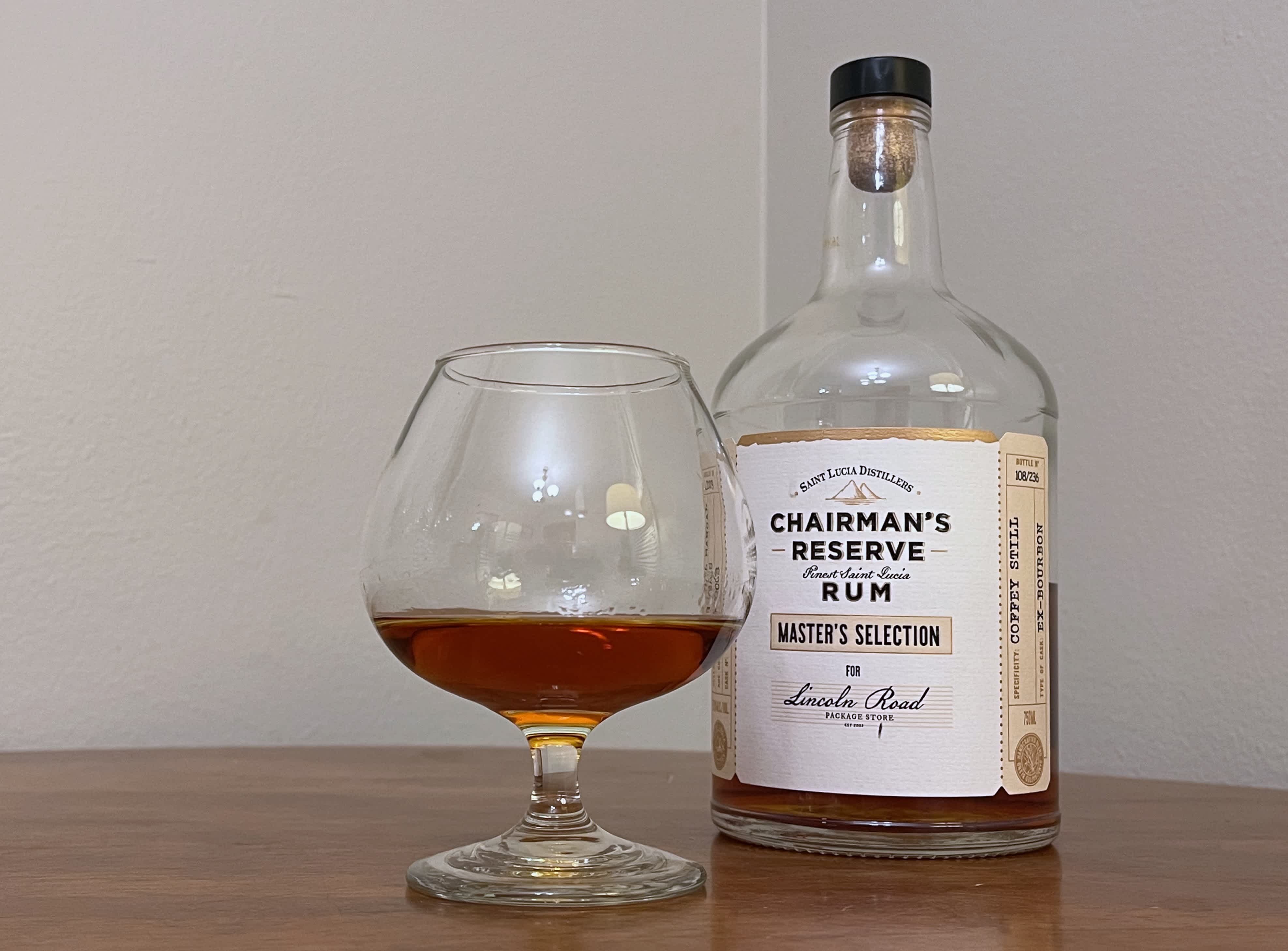 A bottle of Chairman's Reserve Master's Selection next to a glencairn of rum on a table
