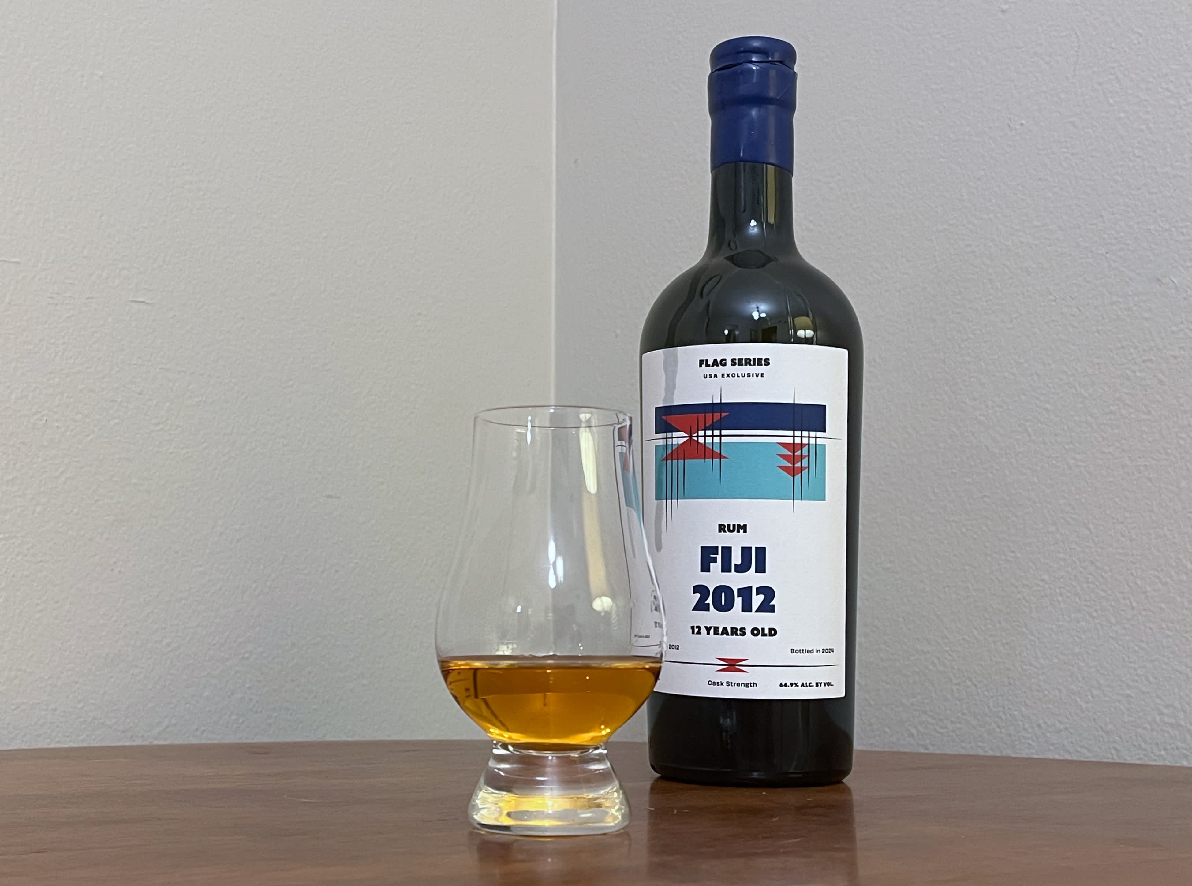 A bottle of Flag Series Fiji 2012 next to a glass of rum