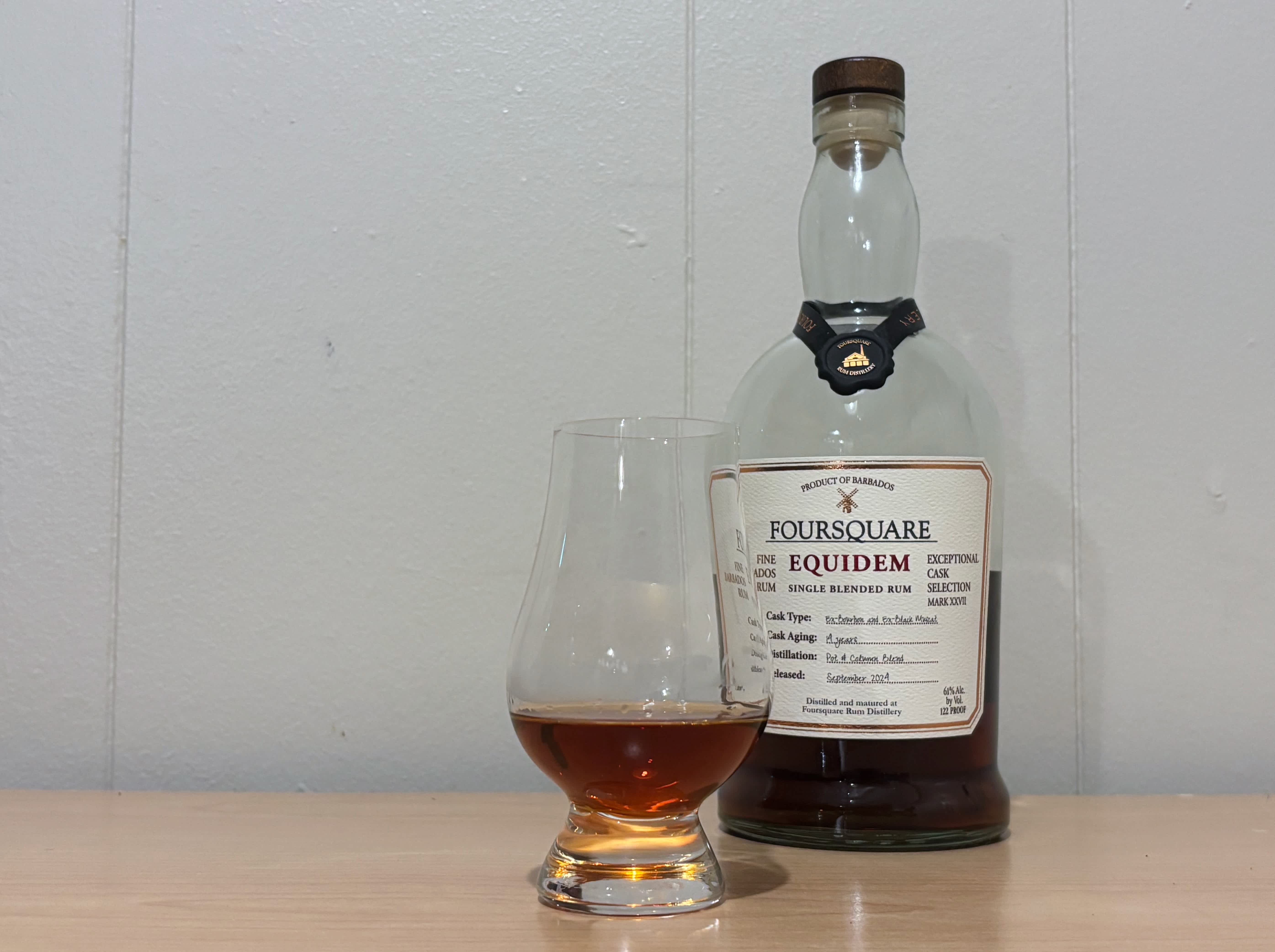 A bottle of Foursquare Equidem next to a glass of rum