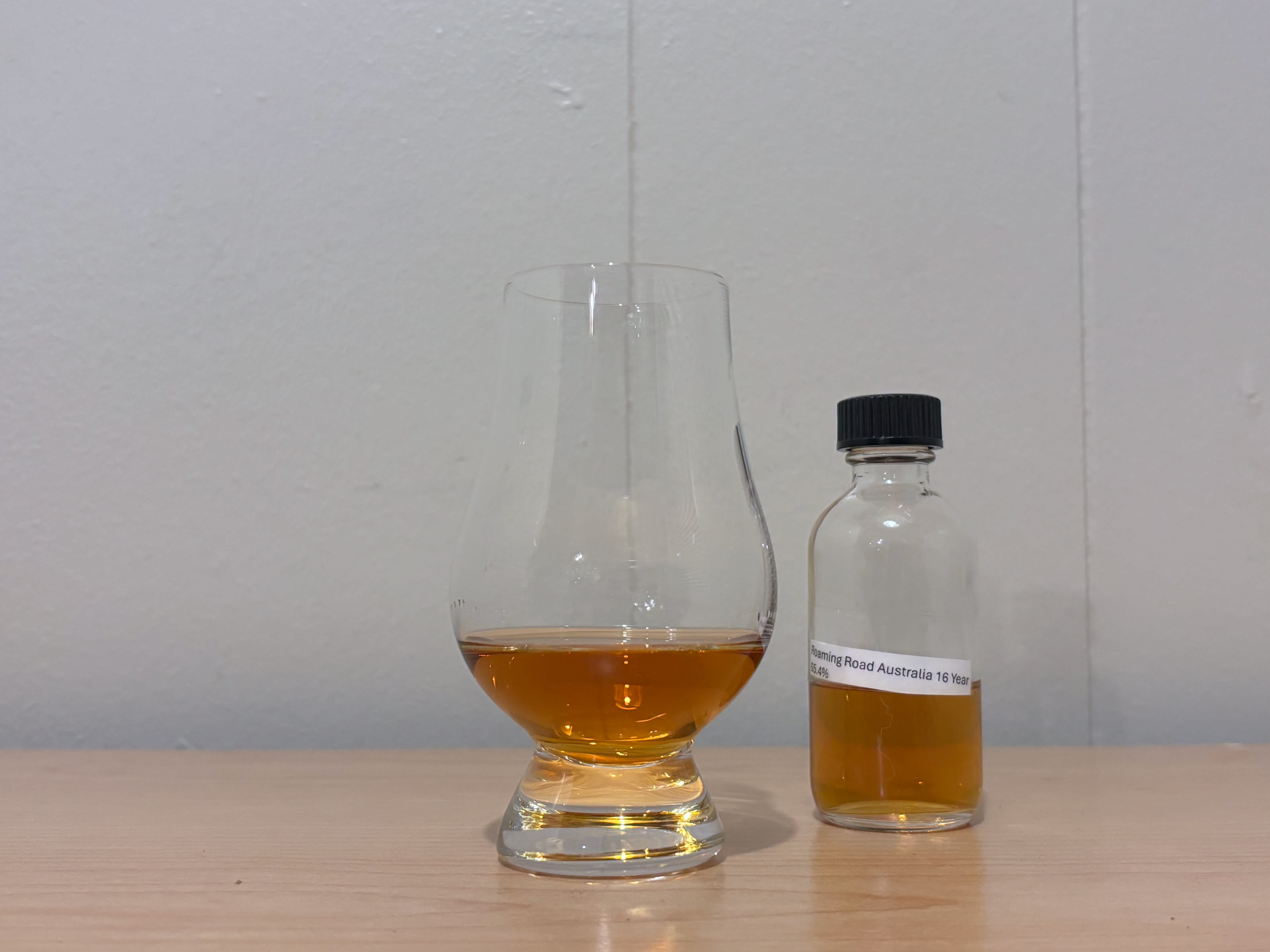 A bottle of Roaming Road Australia 16 year next to a glass of rum