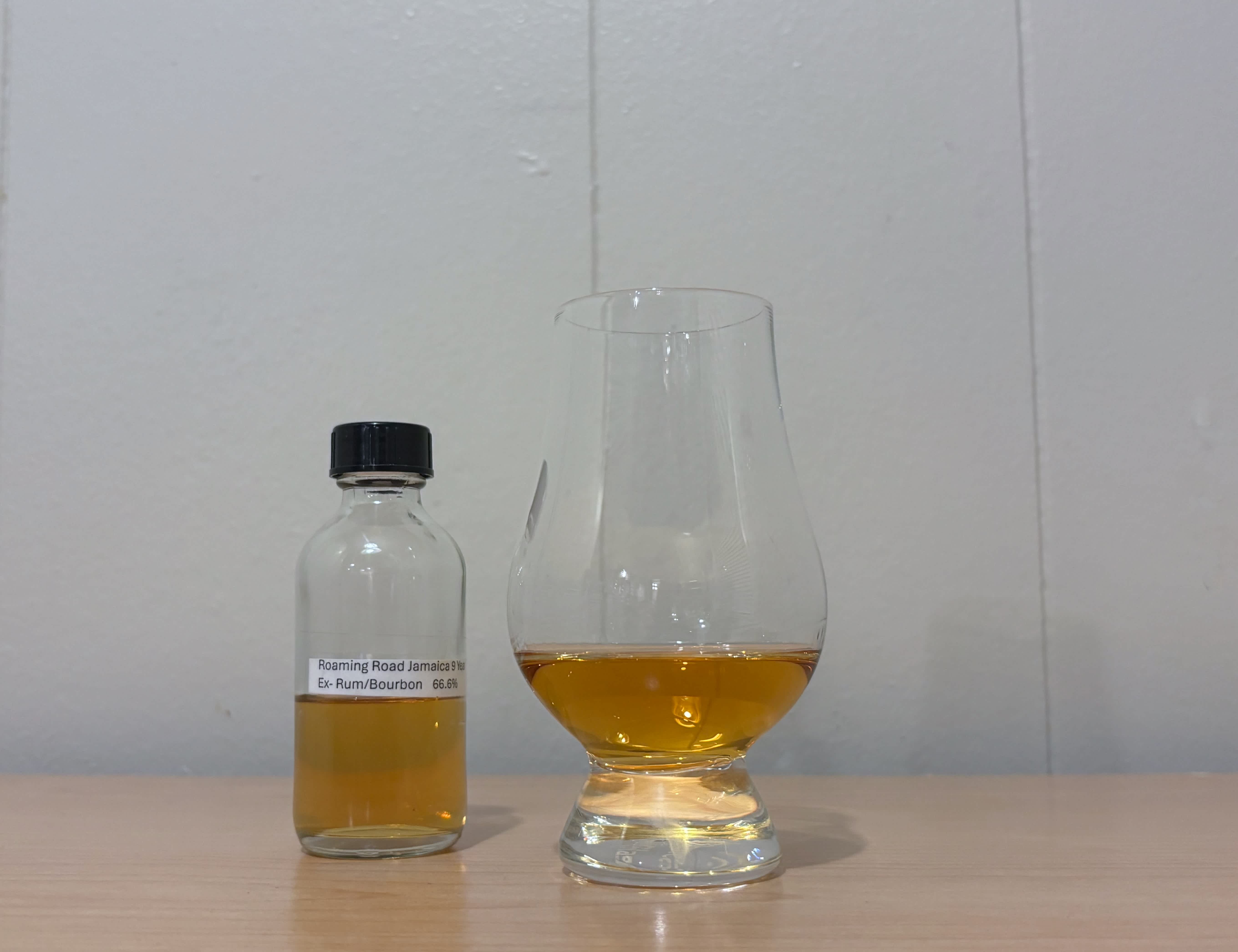A bottle of Roaming Road Jamaica 9 year next to a glass of rum