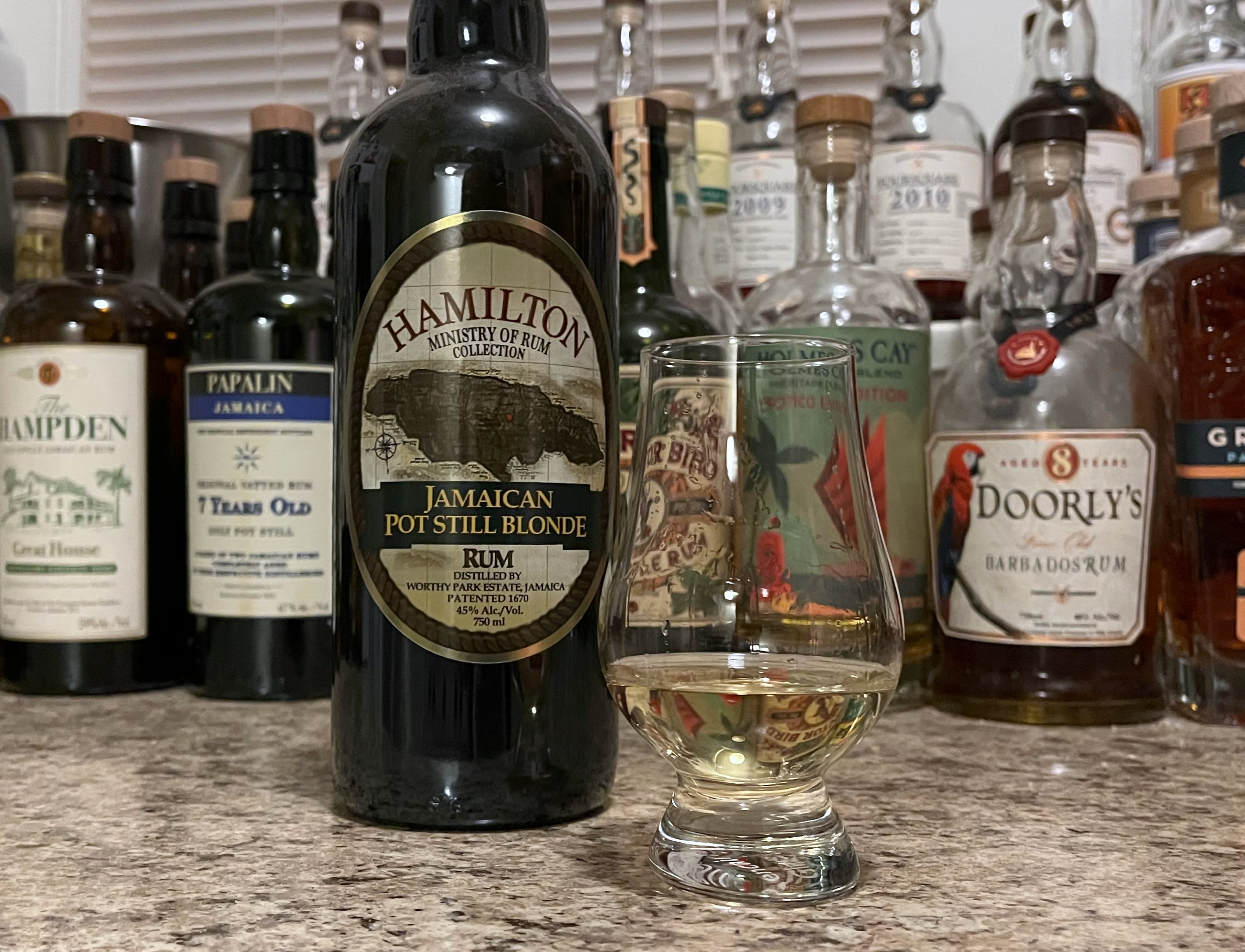 Bottle of Hamilton Pot Still Blonde next to a glass of rum