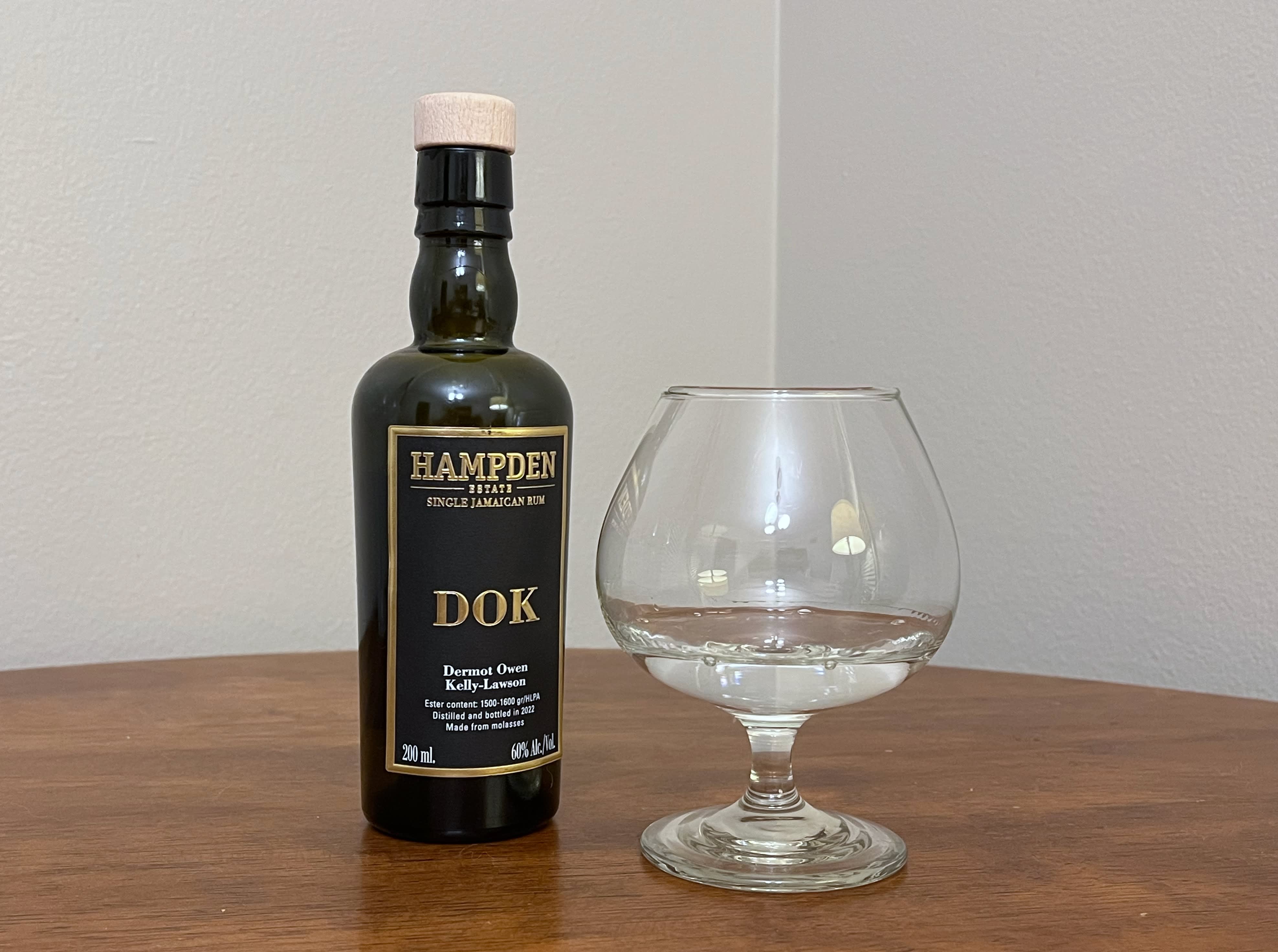 A bottle of Hampden 8 Marks DOK next to a glass of rum