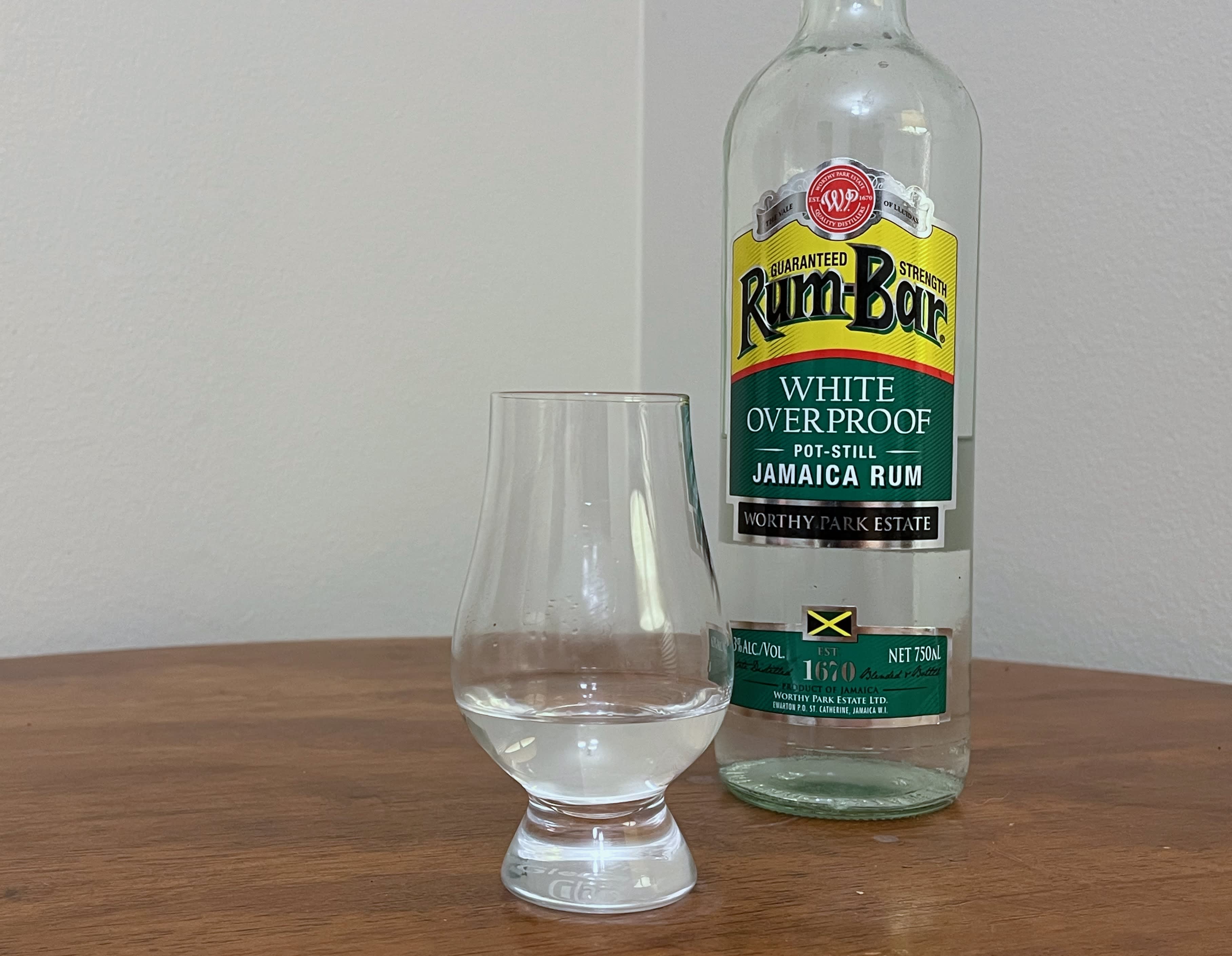 A bottle of Rum-Bar Overproof next to a glass of rum