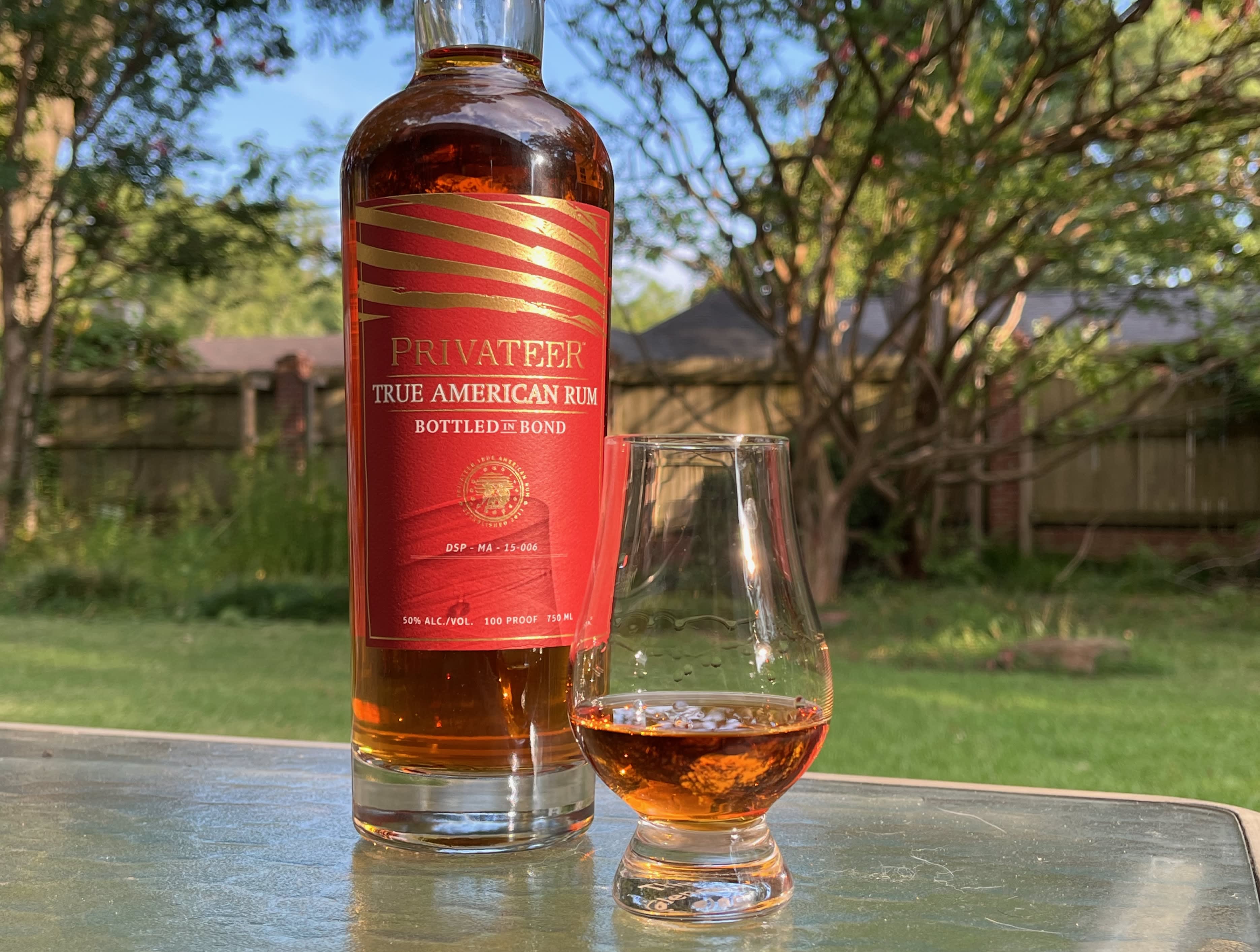 A bottle of Privateer Bottled in Bond next to a glass of rum