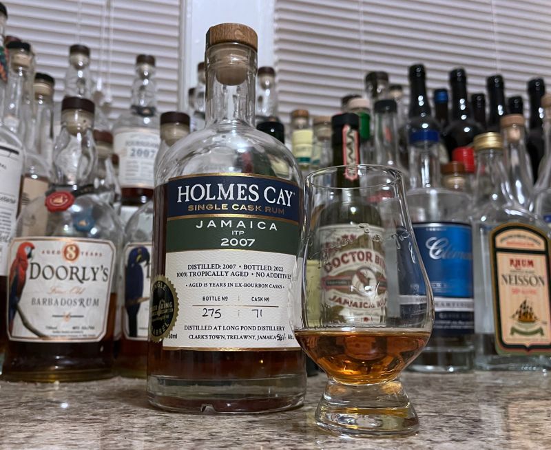 Bottle of Holmes Cay Jamaica ITP 2007 sitting next to a rum-filled glencairn
