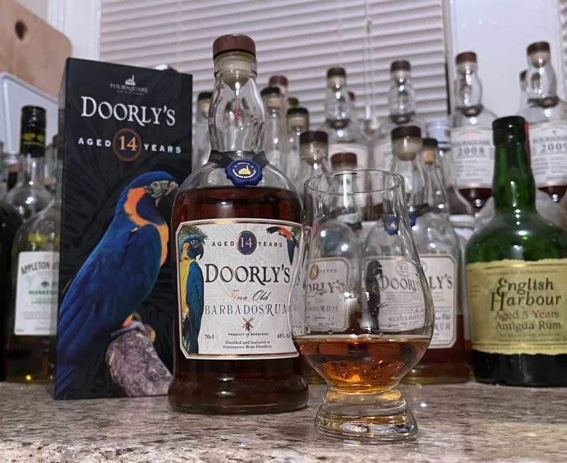A bottle of Doorly's 14 year next to a glencairn of rum