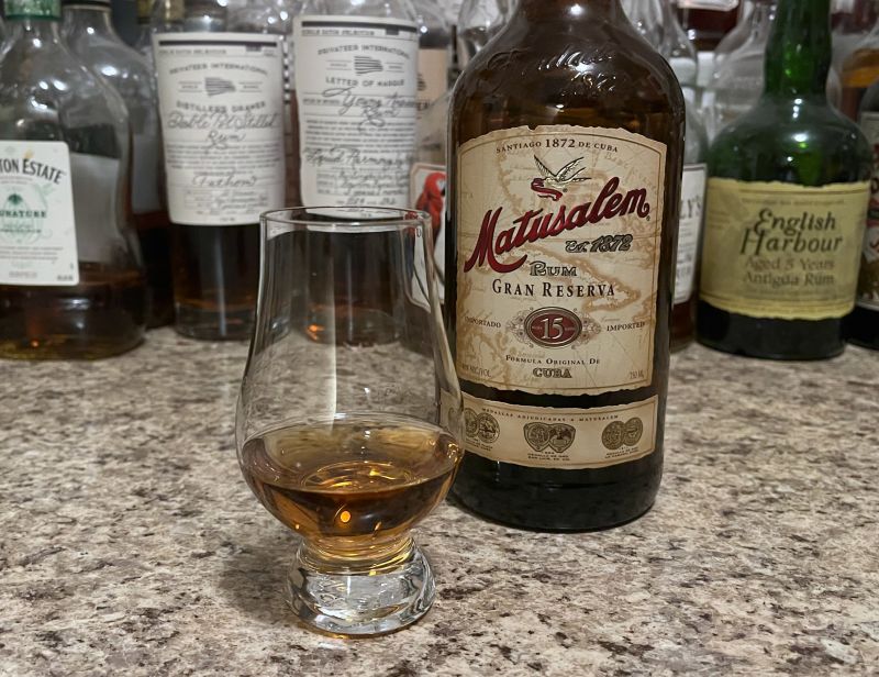 A bottle of Matusalem 15 next to a glencairn of rum