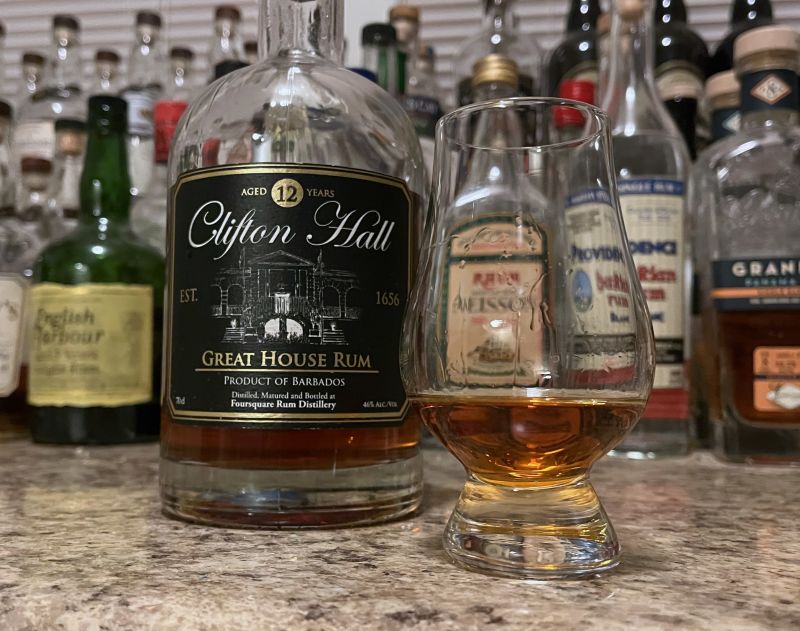 A bottle of Clifton Hall next to a glencairn of rum