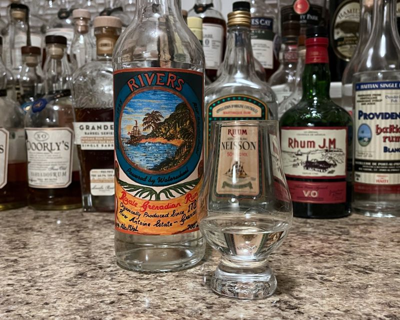 A bottle of Rivers next to a glencairn of rum on a kitchen counter
