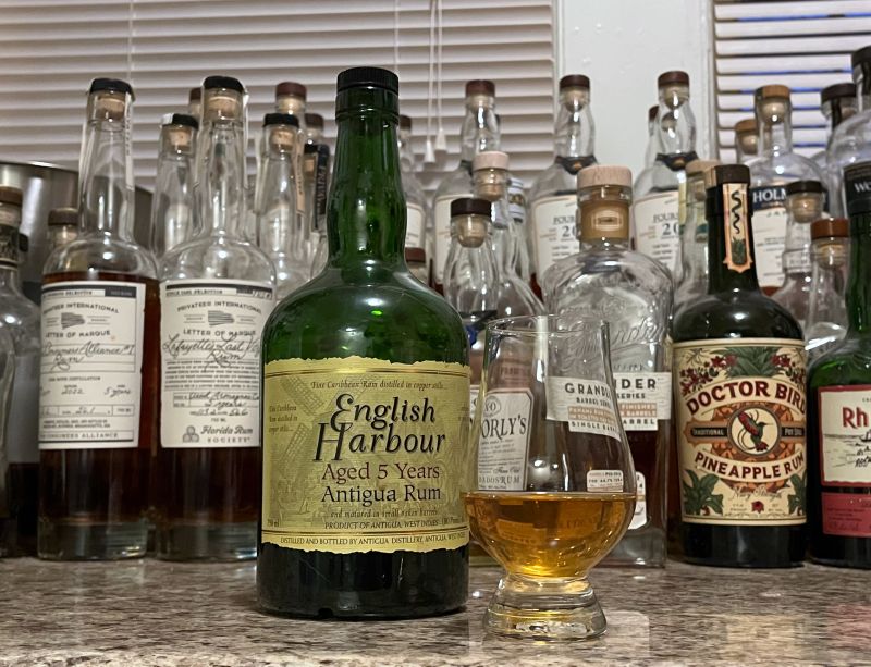 Bottle of English Harbour 5 year on a counter next to a glencairn with rum poured in it