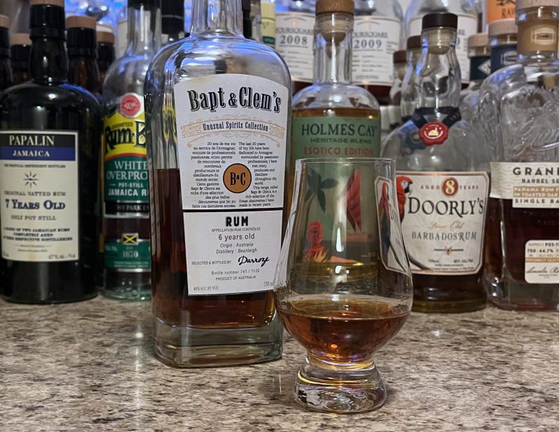 Bapt & Clem's bottle sitting next to a glencairn filled with rum