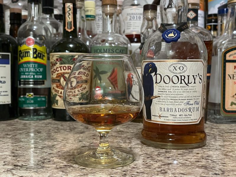 A bottle of Doorly's XO next to a glencairn of rum