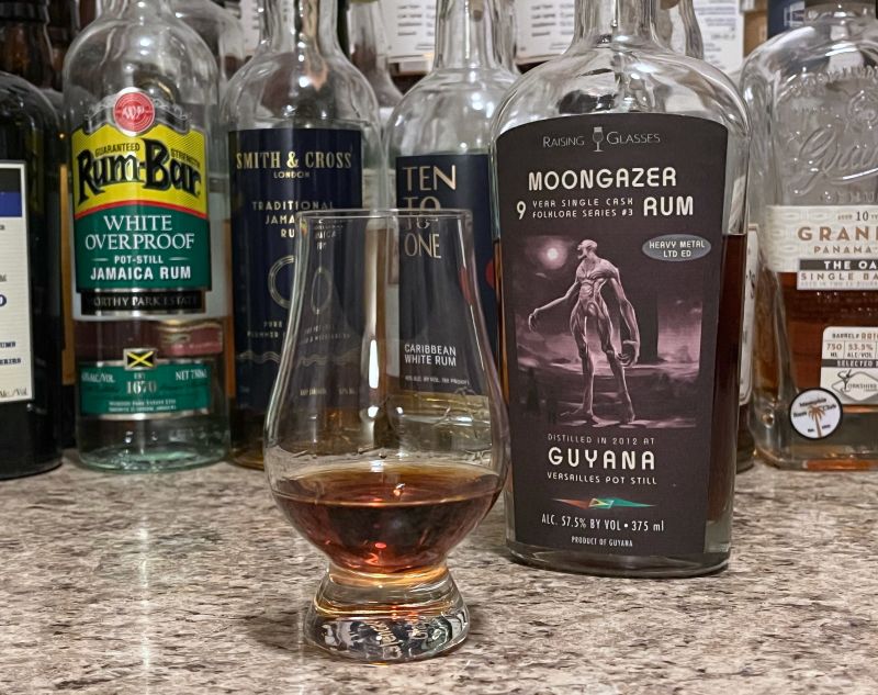Raising Glasses Moongazer bottle next to a glass of rum