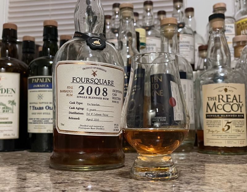 A bottle of Foursquare 2008 next to a glencairn of rum on a kitchen counter
